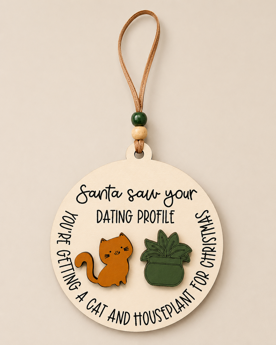 Round Santa Saw Your Dating Profile ornament styled with greenery and warm holiday lights