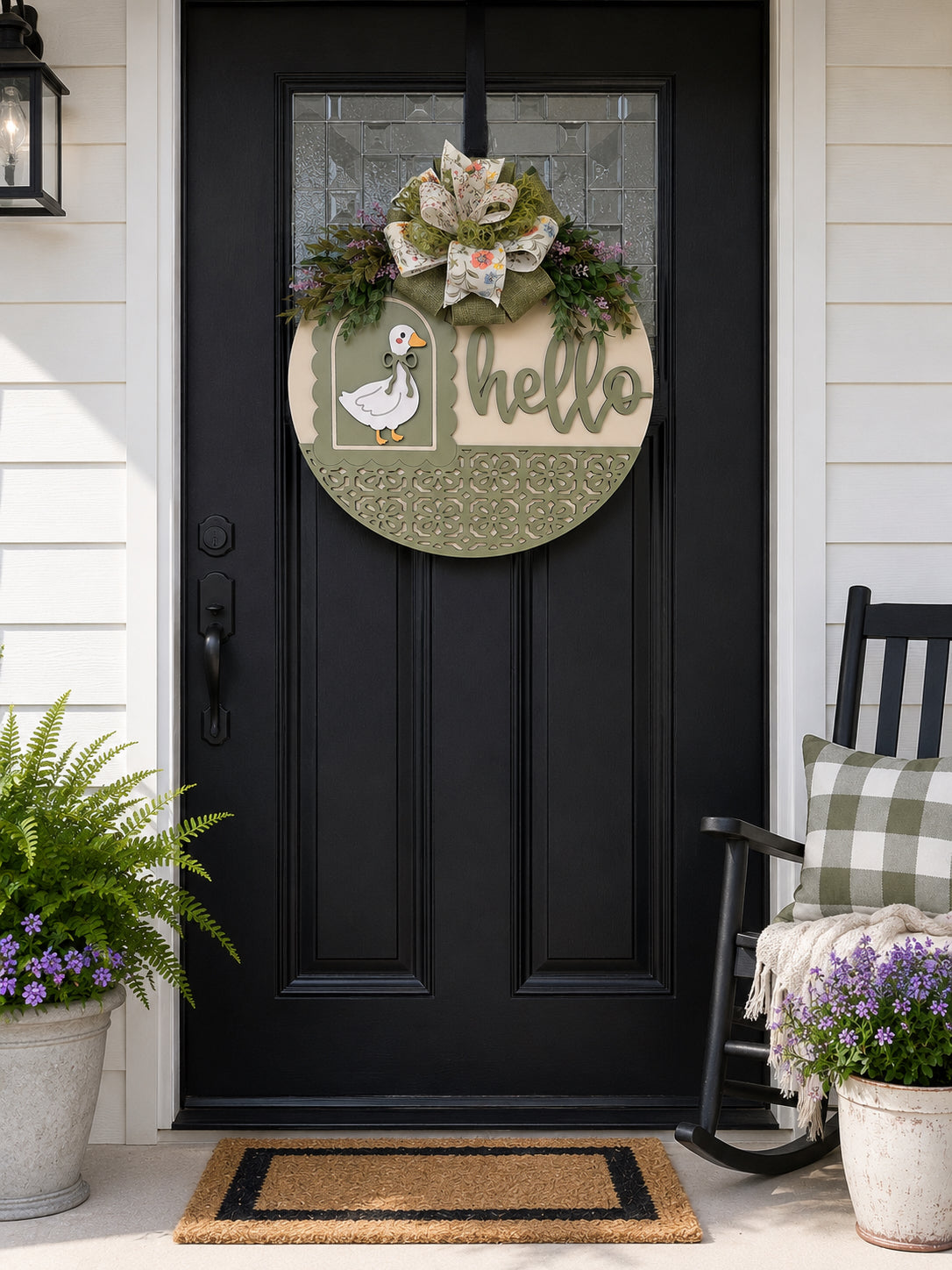 Handmade Hello goose wooden door hanger displayed on a black front door with farmhouse porch décor, showcasing sage green layered wood details, floral bow, and vintage goose design.