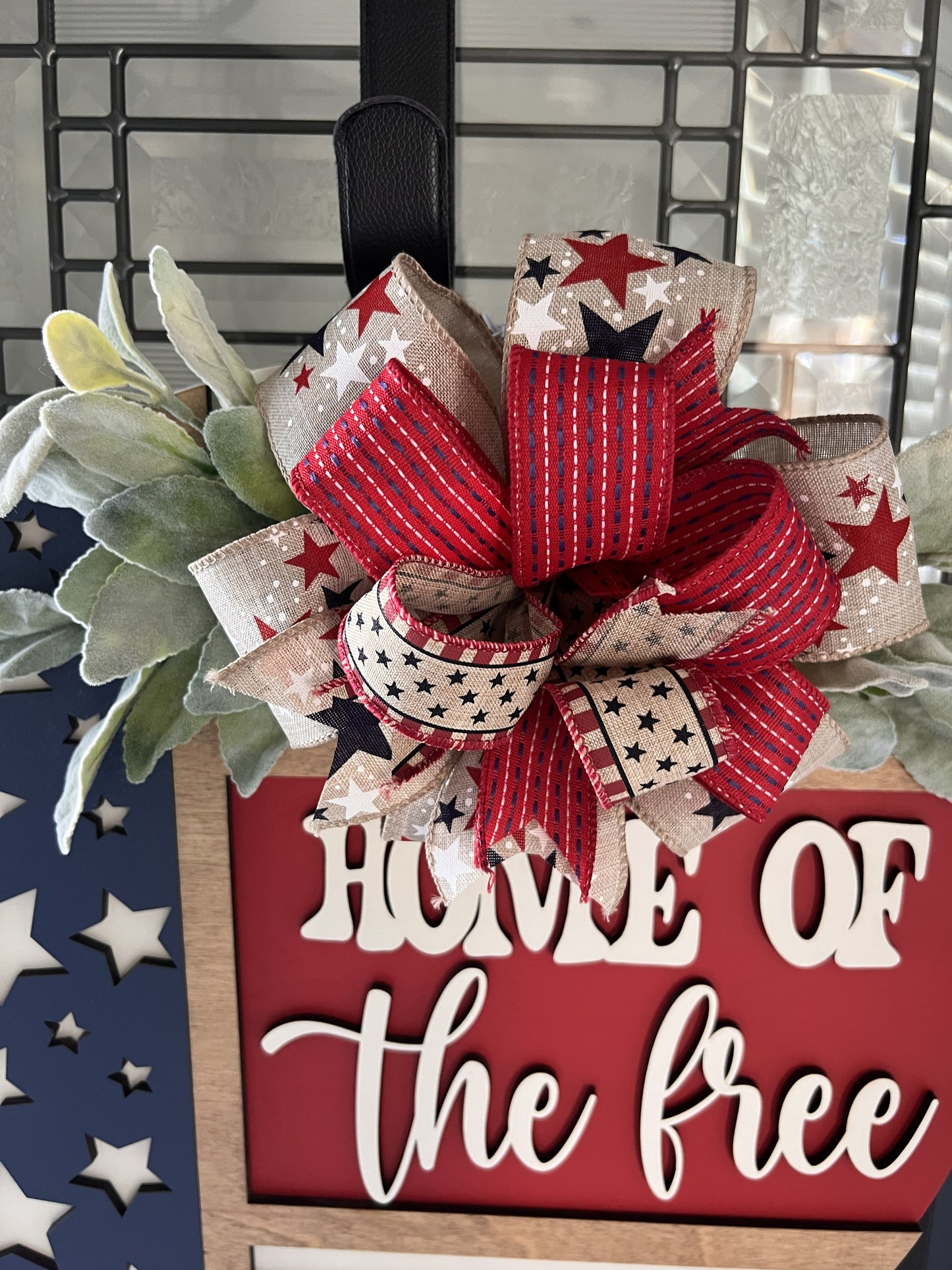 Decorative sign with a red, white, and blue bow and 'Home of the Free' text.