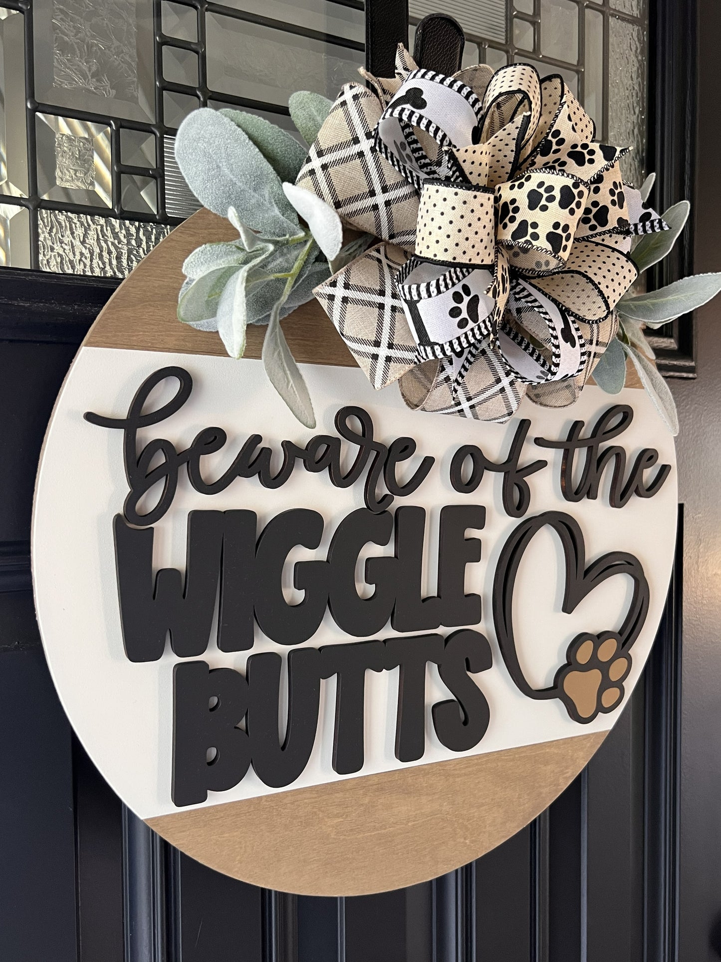 handmade wooden dog sign with black and white pawprint bow and greenery