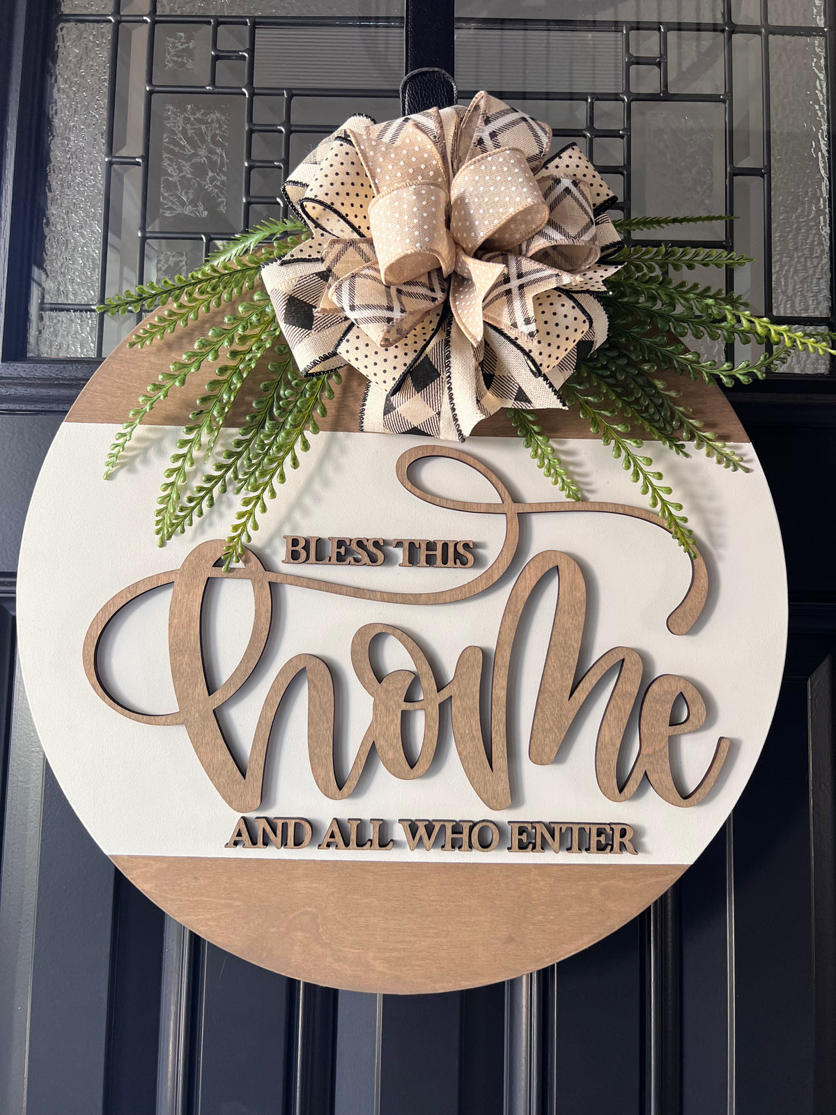 Decorative sign with 'Bless This Home' text and a bow on a door.