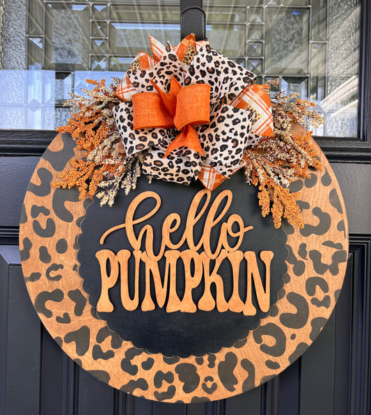 Hello Pumpkin leopard print door hanger full view on black door showing dried berry and floral spray detail with bow
