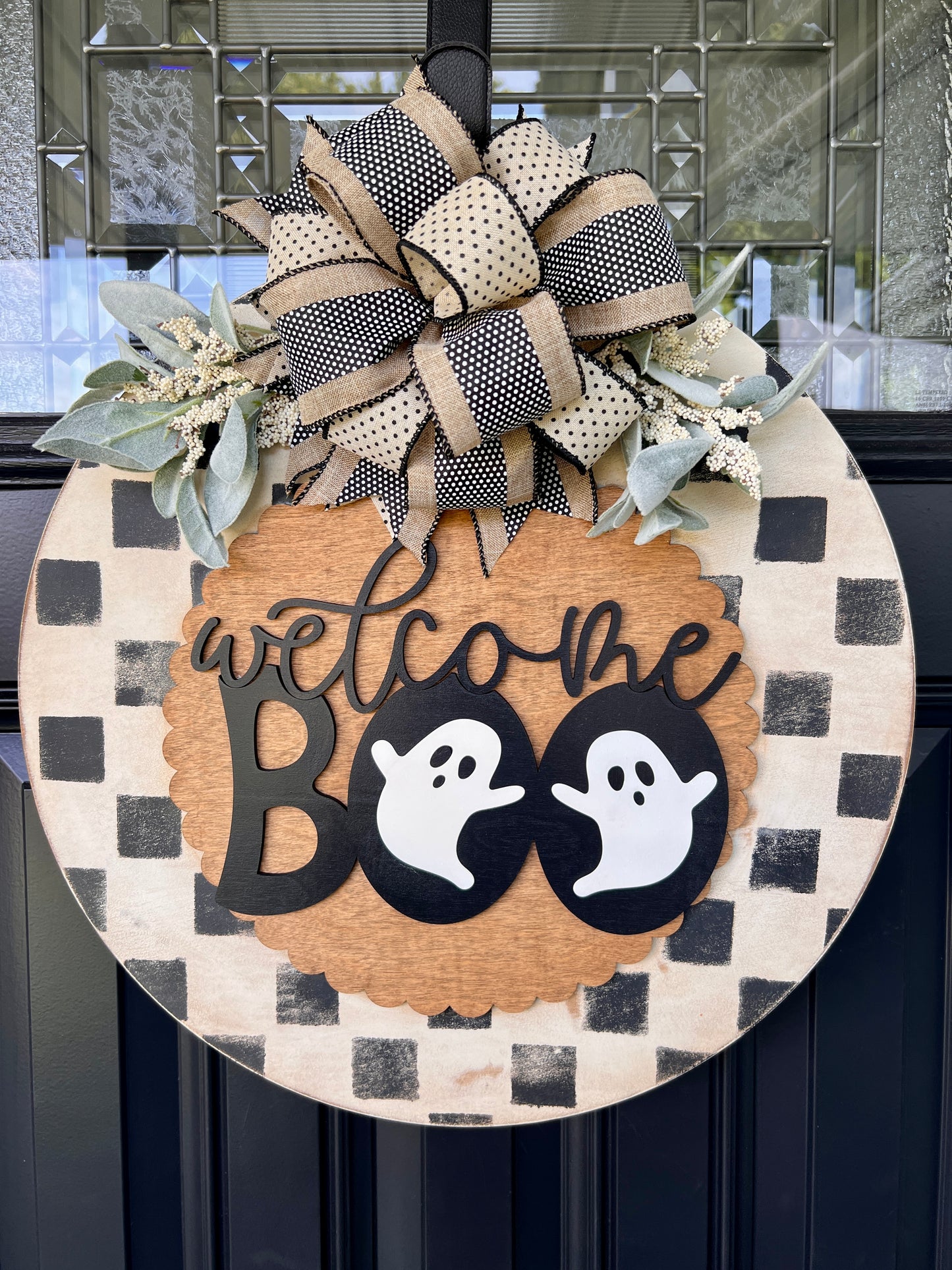 Handmade Welcome Boo Halloween door hanger with ghost accents, black and cream checkered background, layered wood lettering, designer bow, and fall front porch décor.