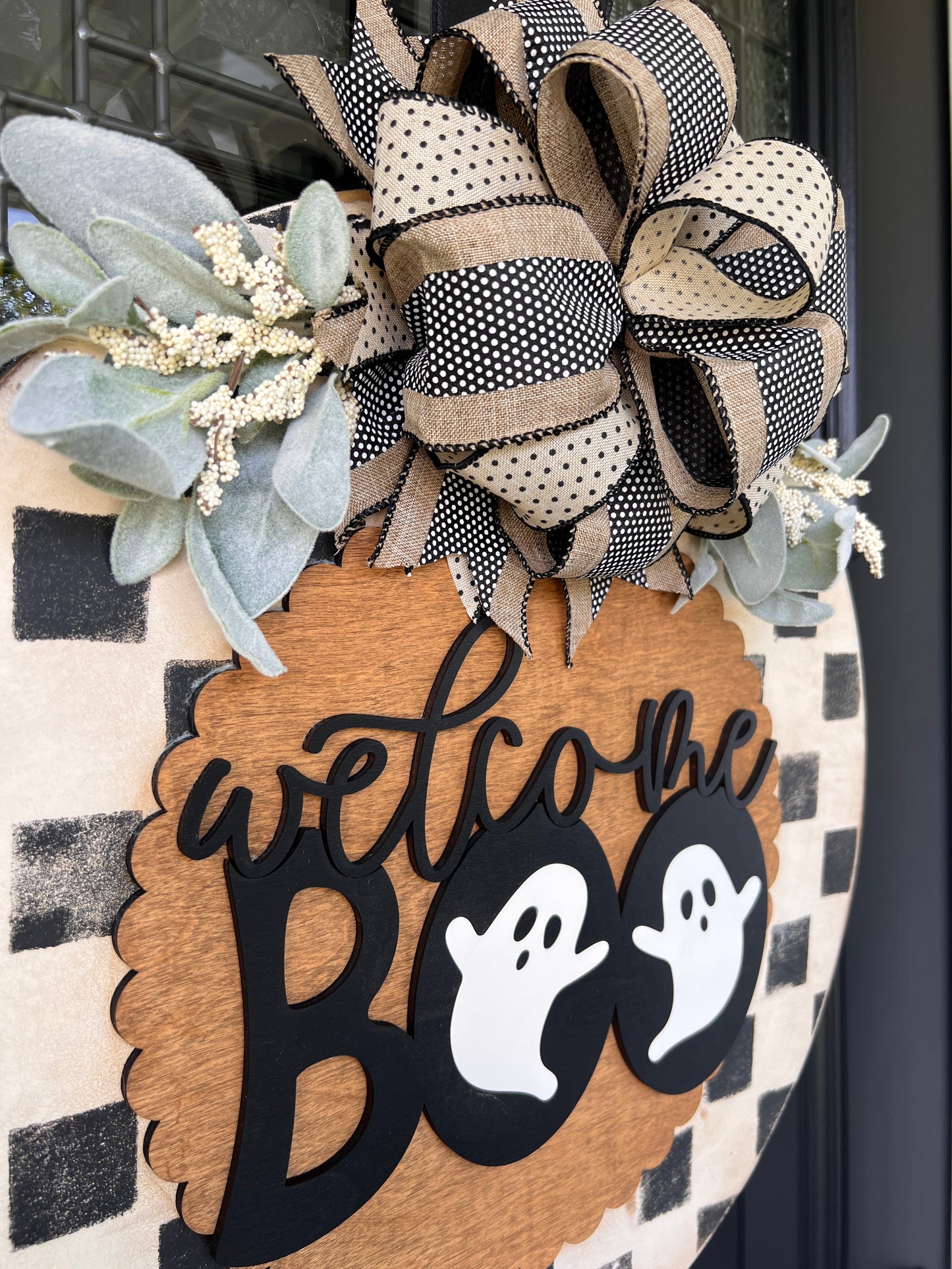 Handmade Welcome Boo Halloween door hanger with ghost accents, black and cream checkered background, layered wood lettering, designer bow, and fall front porch décor.