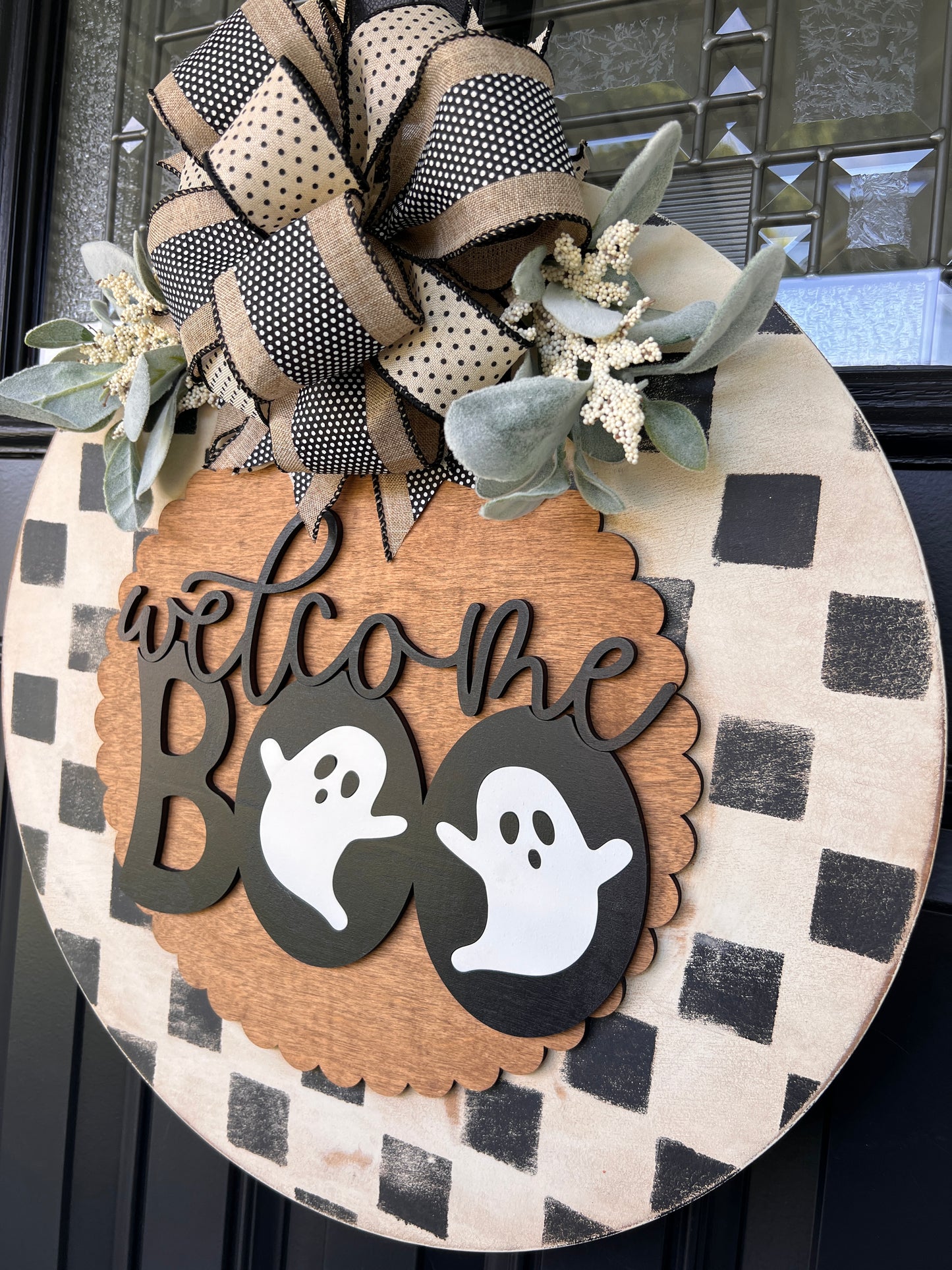 Handmade Welcome Boo Halloween door hanger with ghost accents, black and cream checkered background, layered wood lettering, designer bow, and fall front porch décor.