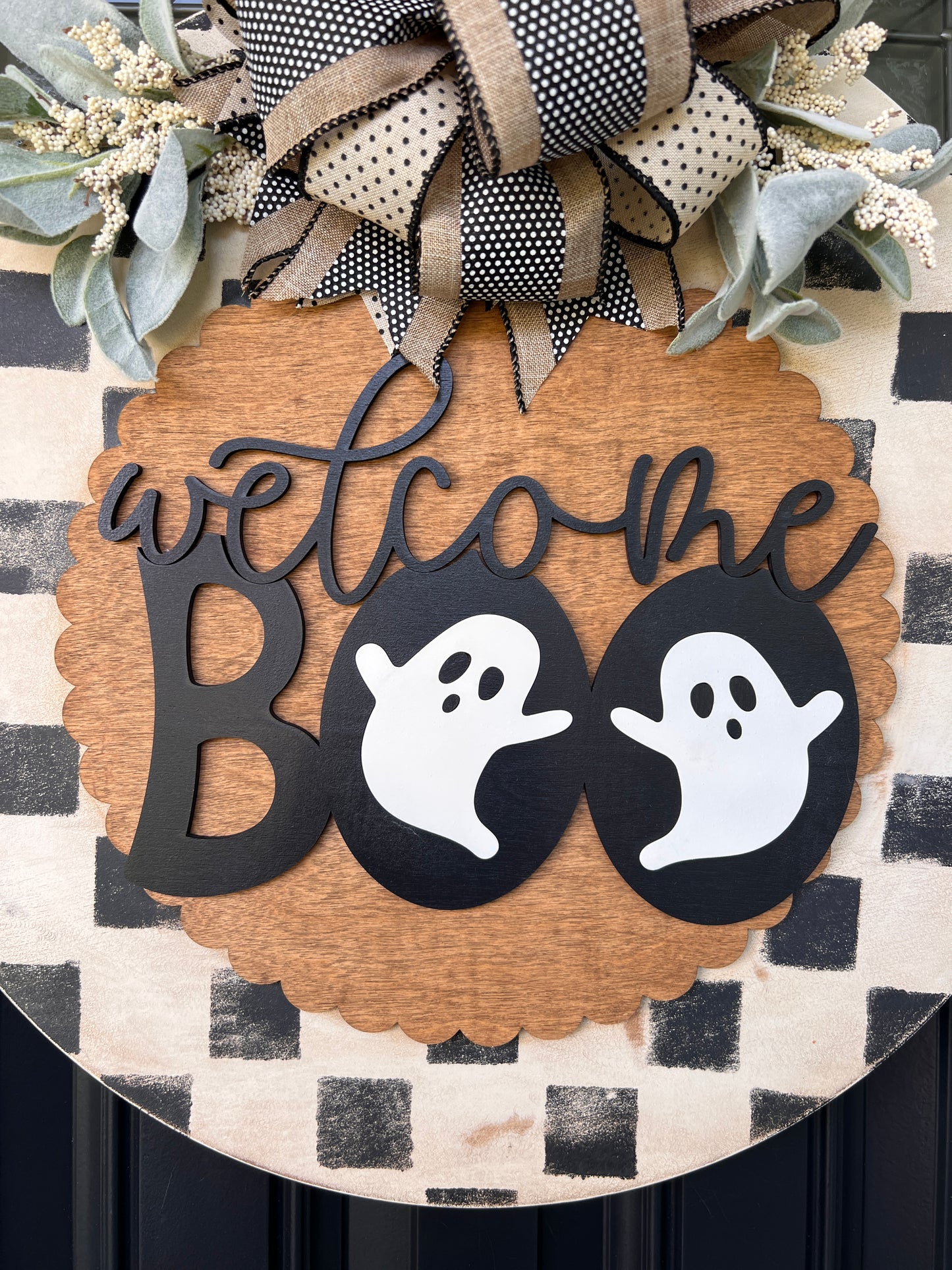 Handmade Welcome Boo Halloween door hanger with ghost accents, black and cream checkered background, layered wood lettering, designer bow, and fall front porch décor.
