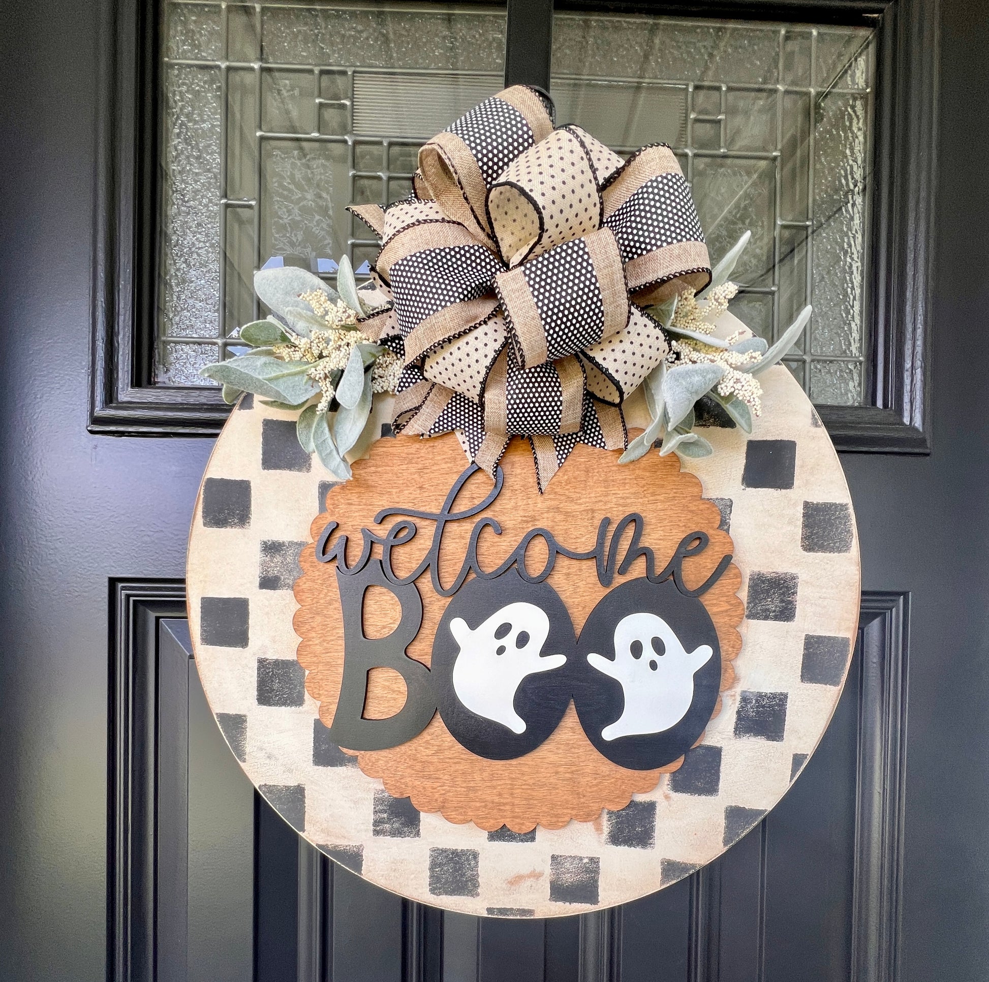 Handmade Welcome Boo Halloween door hanger with ghost accents, black and cream checkered background, layered wood lettering, designer bow, and fall front porch décor.