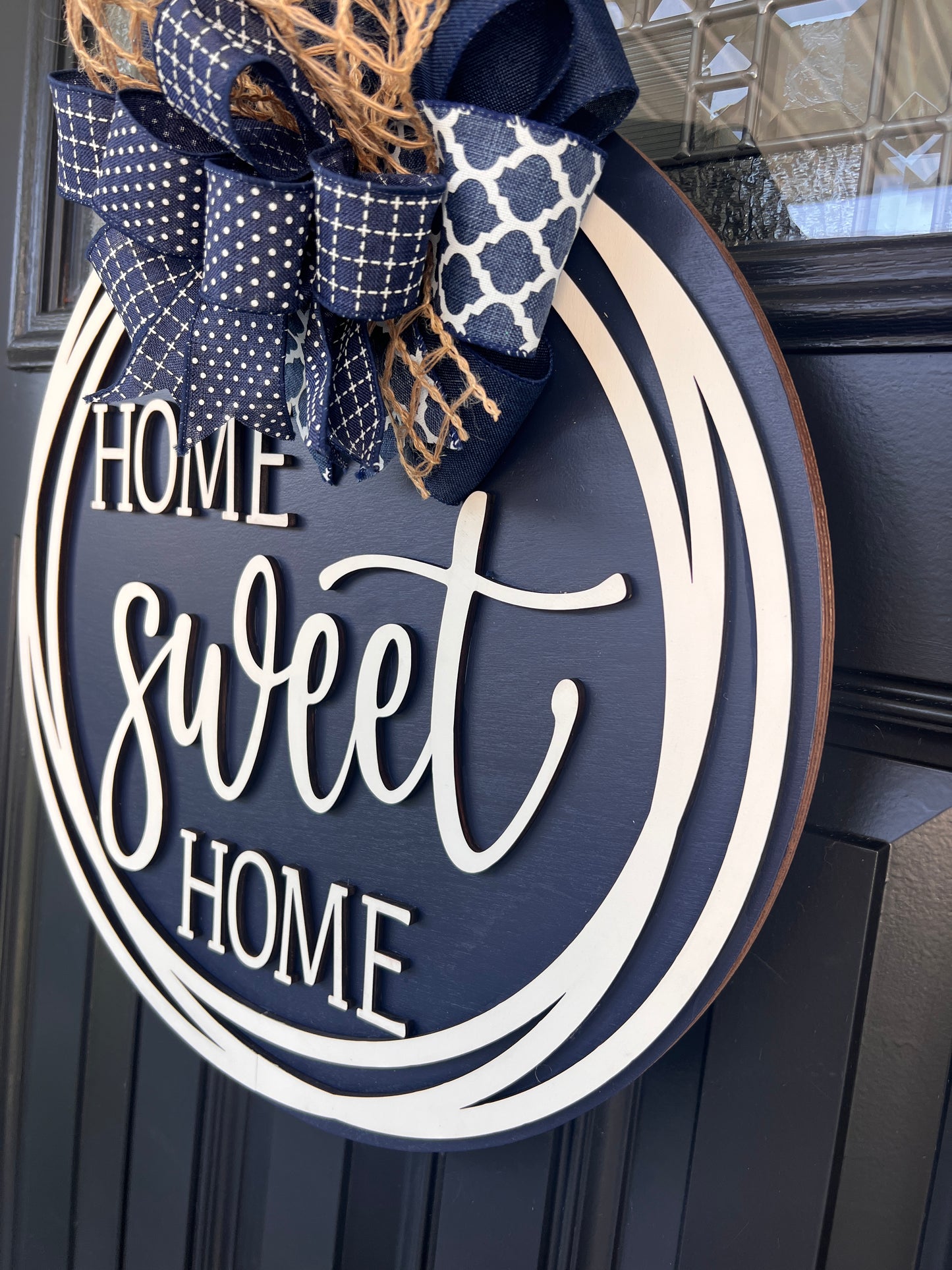 Home Sweet Home navy door hanger angled close up showing 3D cream HOME sweet HOME lettering against rich navy background