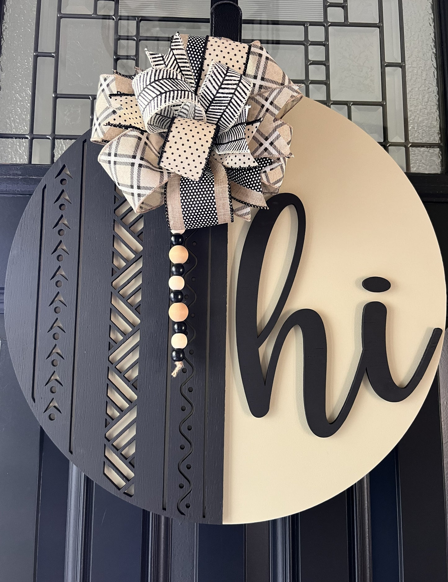 modern hi door hanger with black geometric wood design and neutral cream background