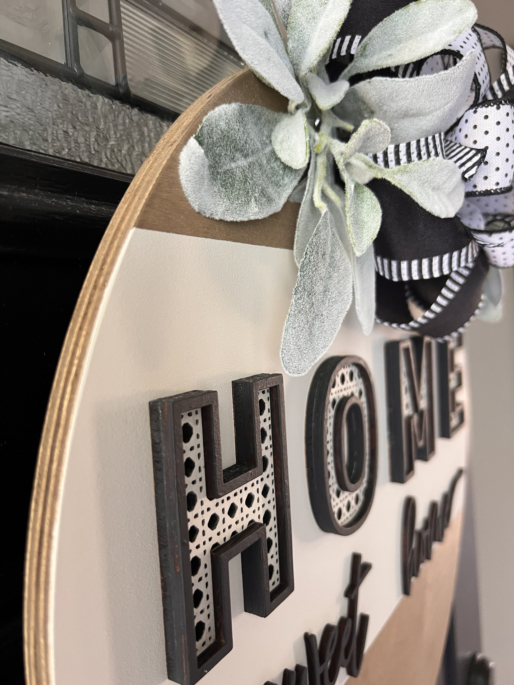 “Home Sweet Home black and white wooden door hanger with layered lettering, decorative bow and greenery on front door” Boho vibe 