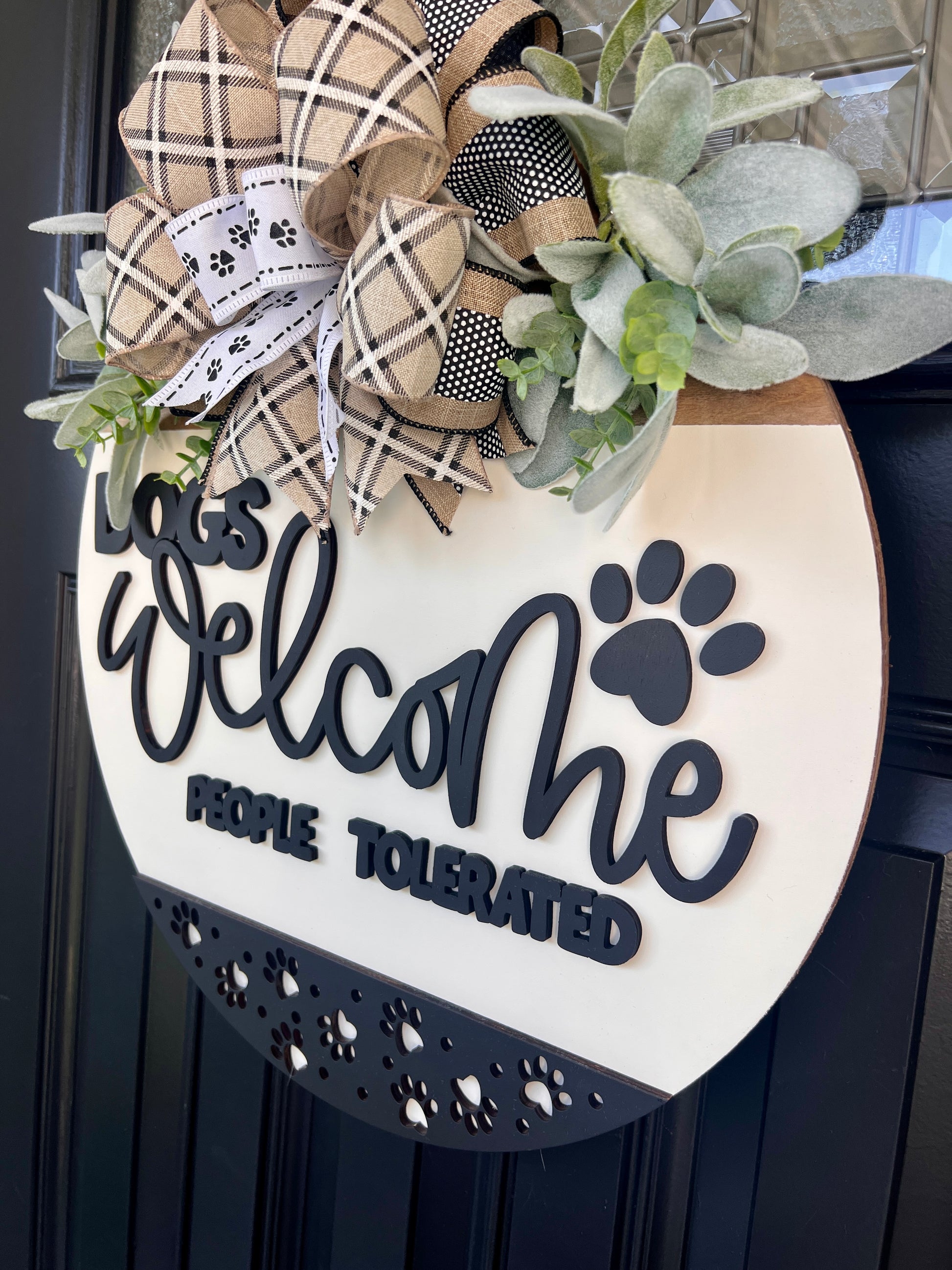 Dogs Welcome People Tolerated door hanger close up of 3D charcoal lettering and paw print on white birchwood round