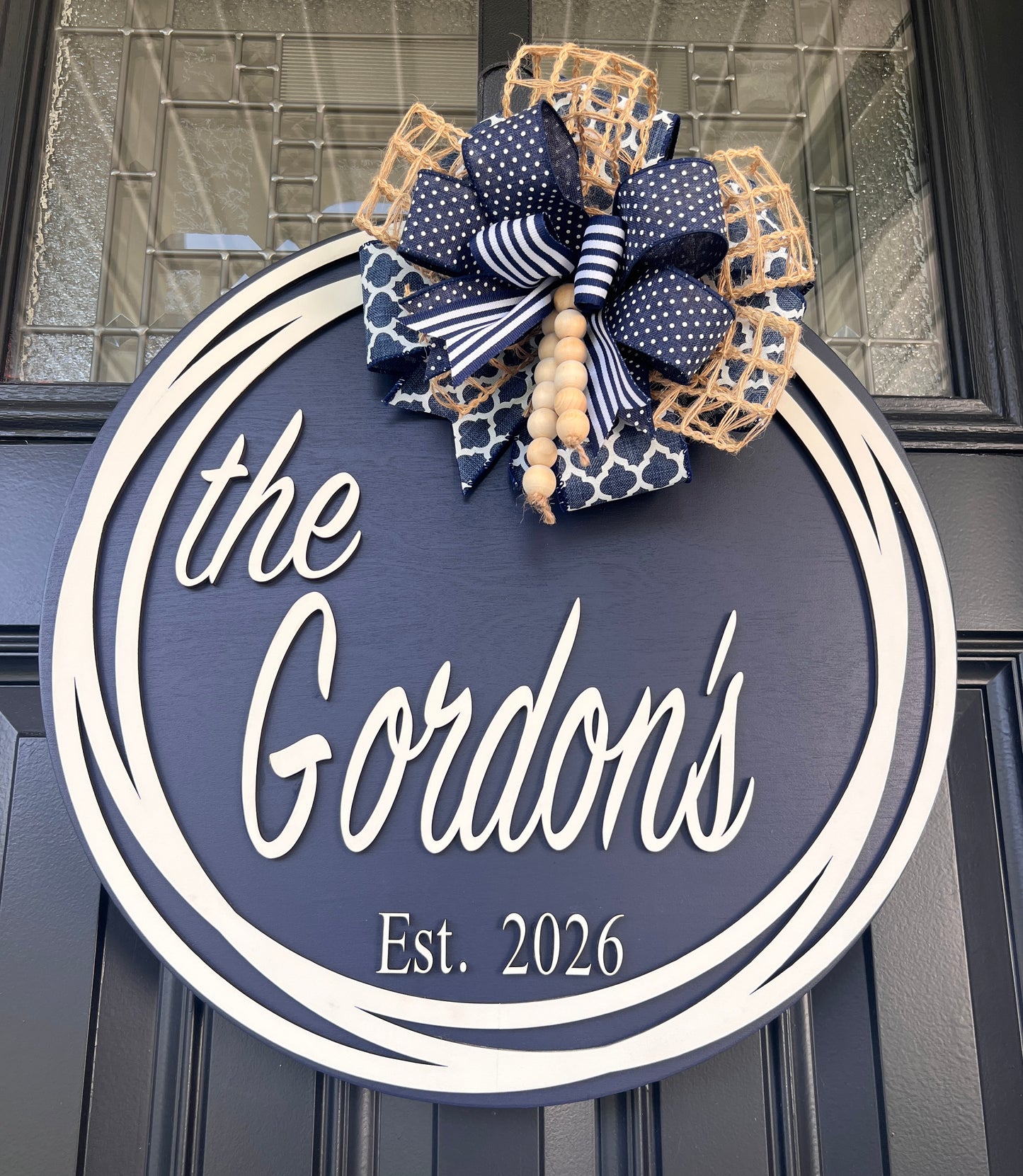 Custom name door hanger close up showing Est 2026 detail below Gordons script lettering on navy background