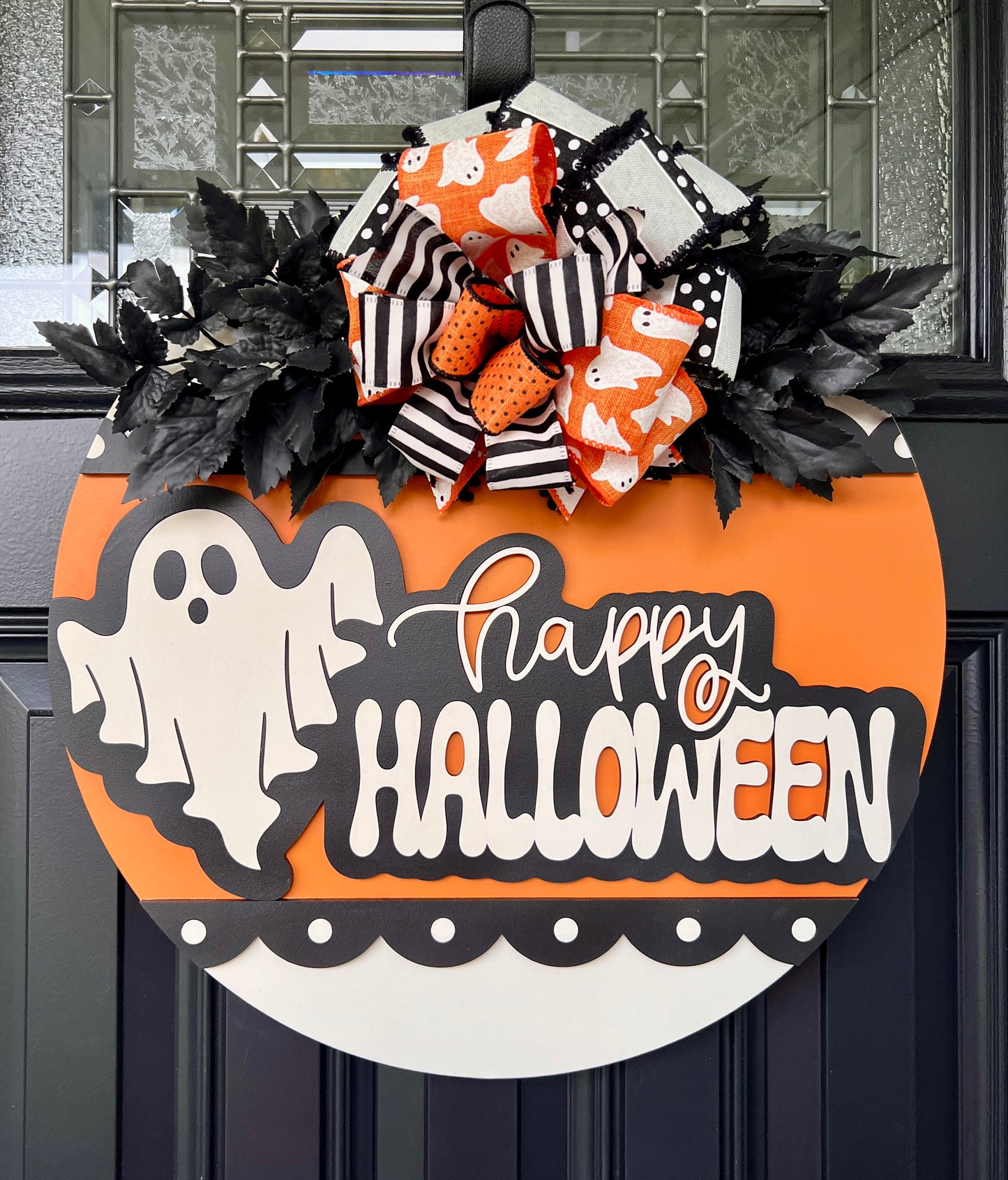 Happy Halloween ghost door hanger on black front door with orange birchwood round and layered ghost print bow with black leaf sprays
