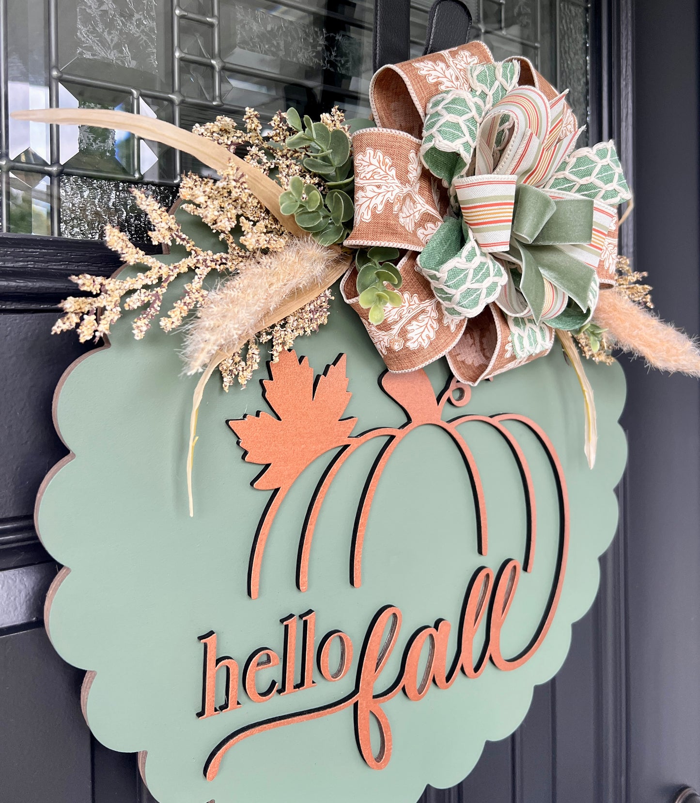 Hello fall scalloped door hanger full front view on black door with mixed ribbon bow and dried botanicals