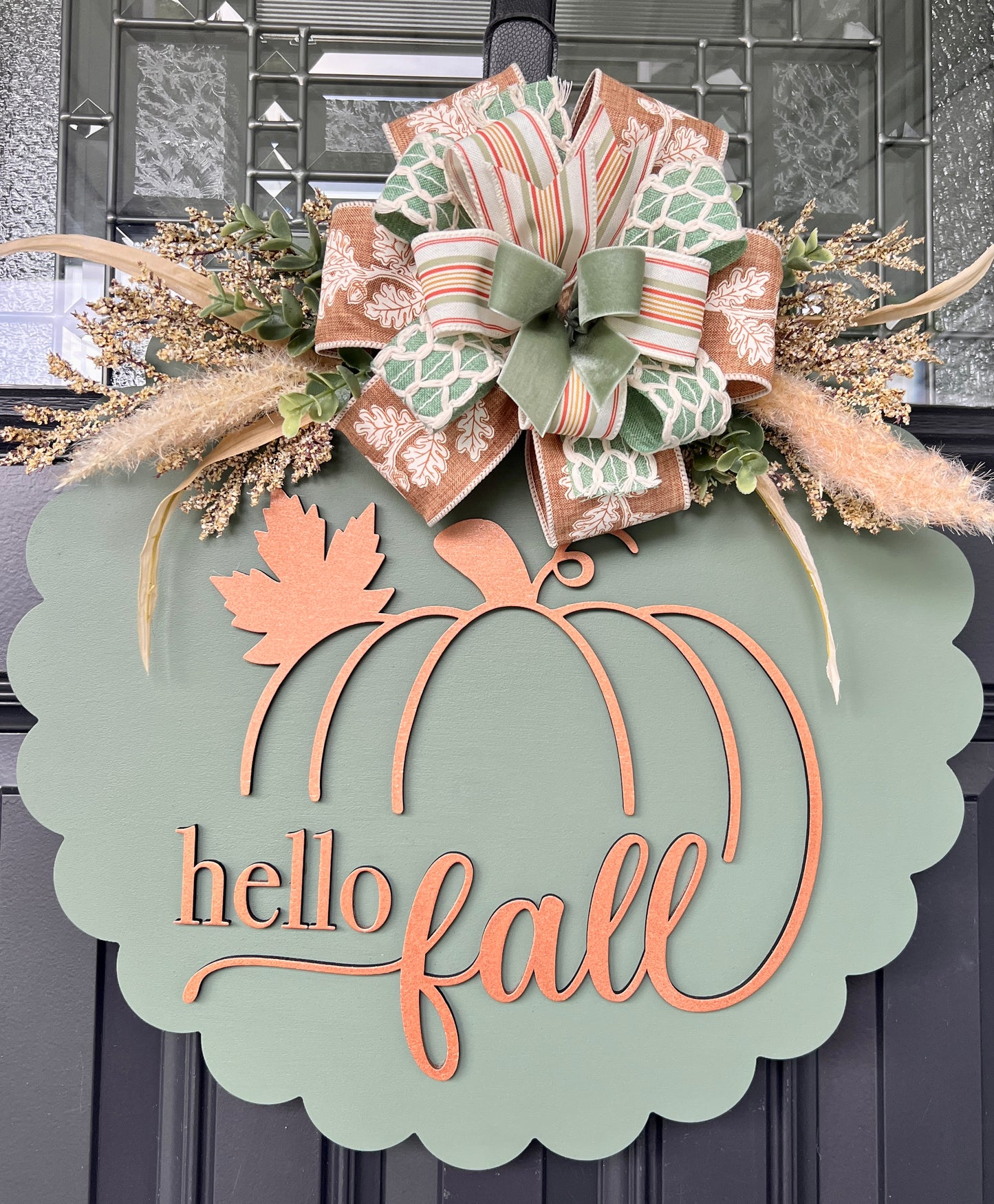 Full view of 18 inch hello fall door hanger with mixed wired ribbon bow and preserved botanical accents on front door