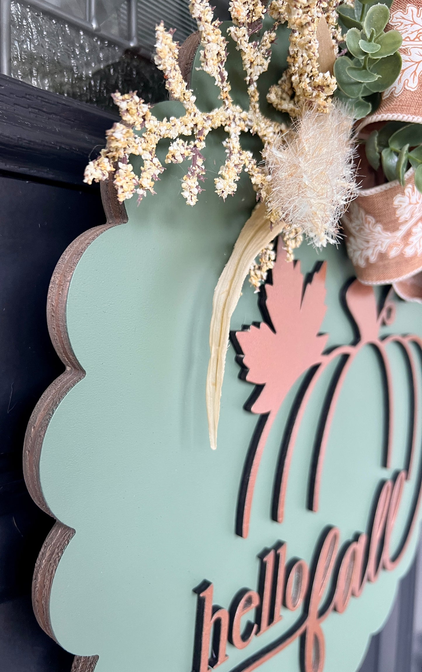 Close up of copper pumpkin and hello fall lettering on sage scalloped door hanger