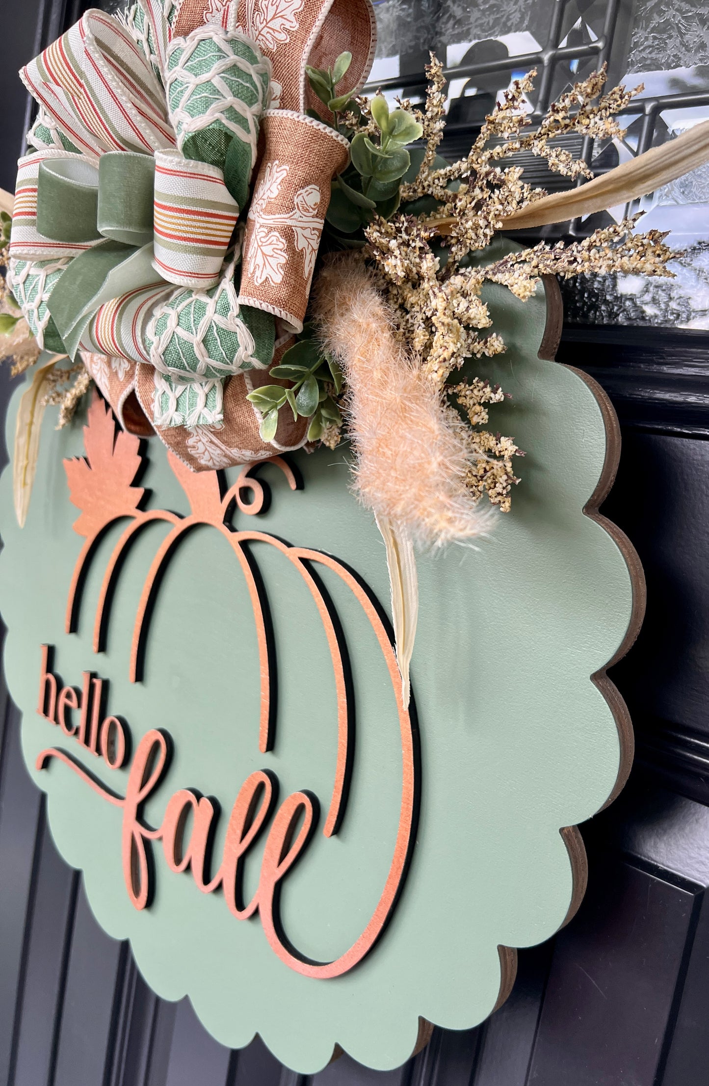 Close up of copper laser cut pumpkin overlay and hello fall script lettering on sage green background