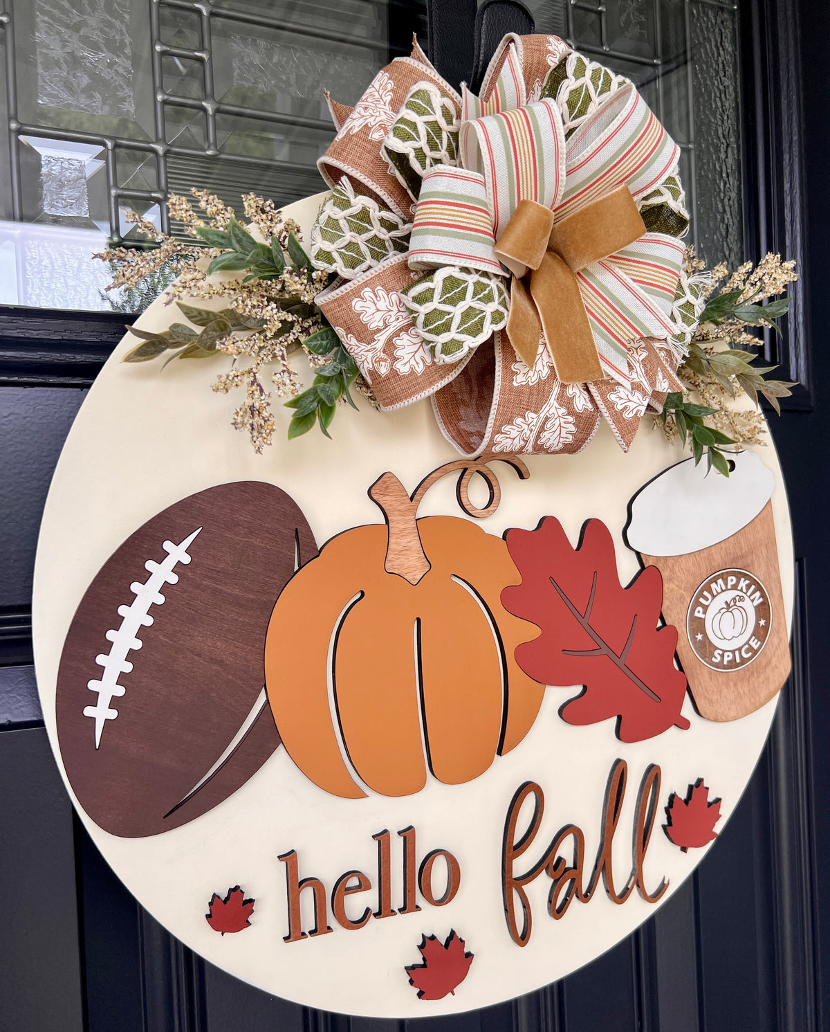 18-inch Hello Fall door hanger featuring a football, orange pumpkin, oak leaf, pumpkin spice coffee cup, maple leaves, greenery, and fall ribbon bow