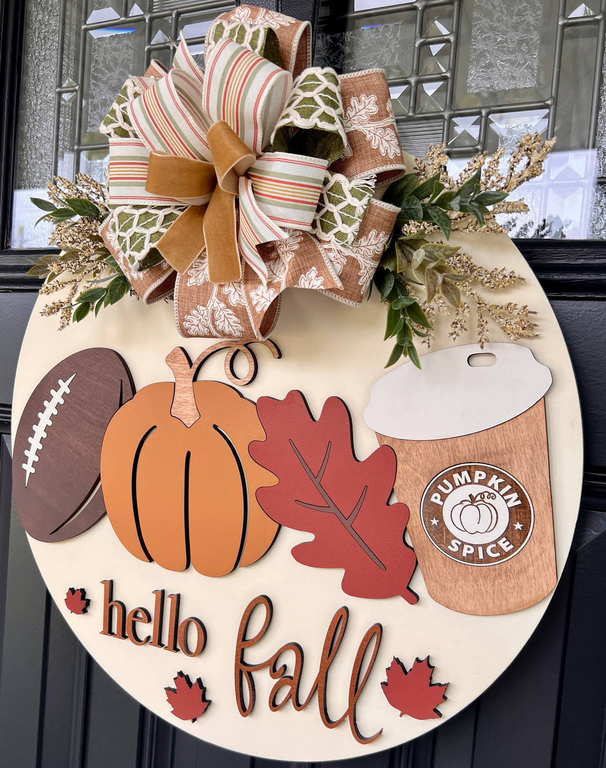 Front view of handmade birchwood fall door hanger with layered football, pumpkin, red leaf, pumpkin spice cup, Hello Fall lettering, and autumn bow