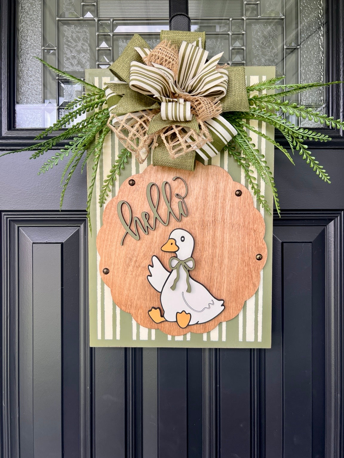 Hello Goose door sign lifestyle shot on porch console table with potted plants showing full 12x18 sign