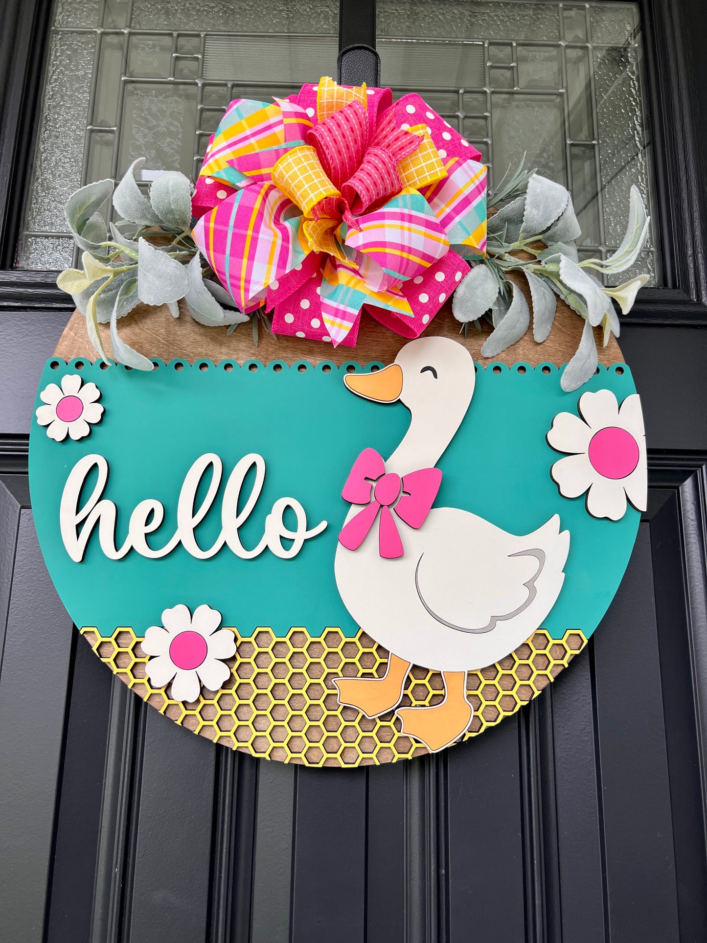 Hello Goose teal spring door hanger on black front door with oversized hot pink polka dot and plaid bow and lambs ear greenery