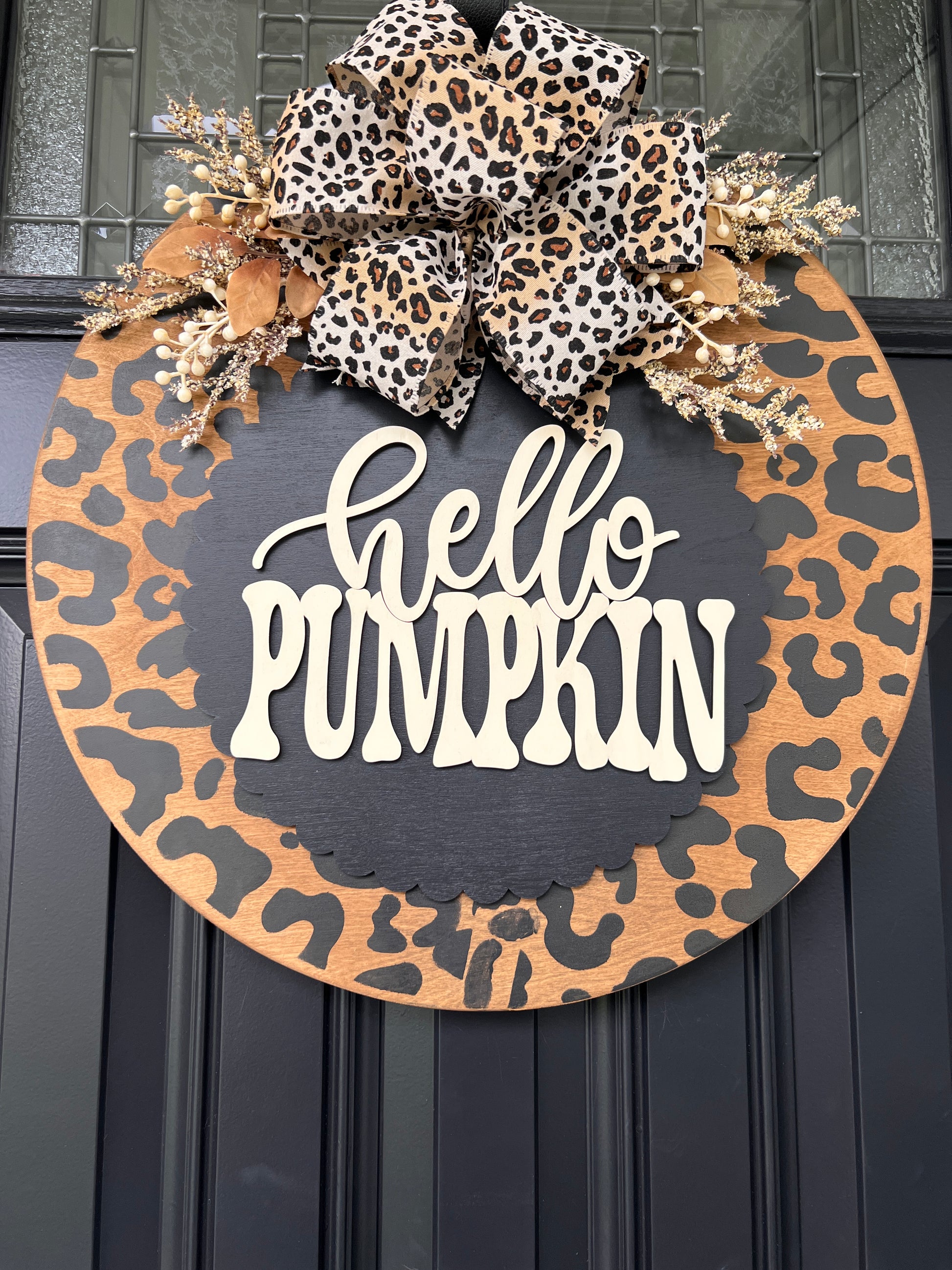 Hello Pumpkin leopard print fall door hanger on black front door with oversized leopard bow and cream berry sprays