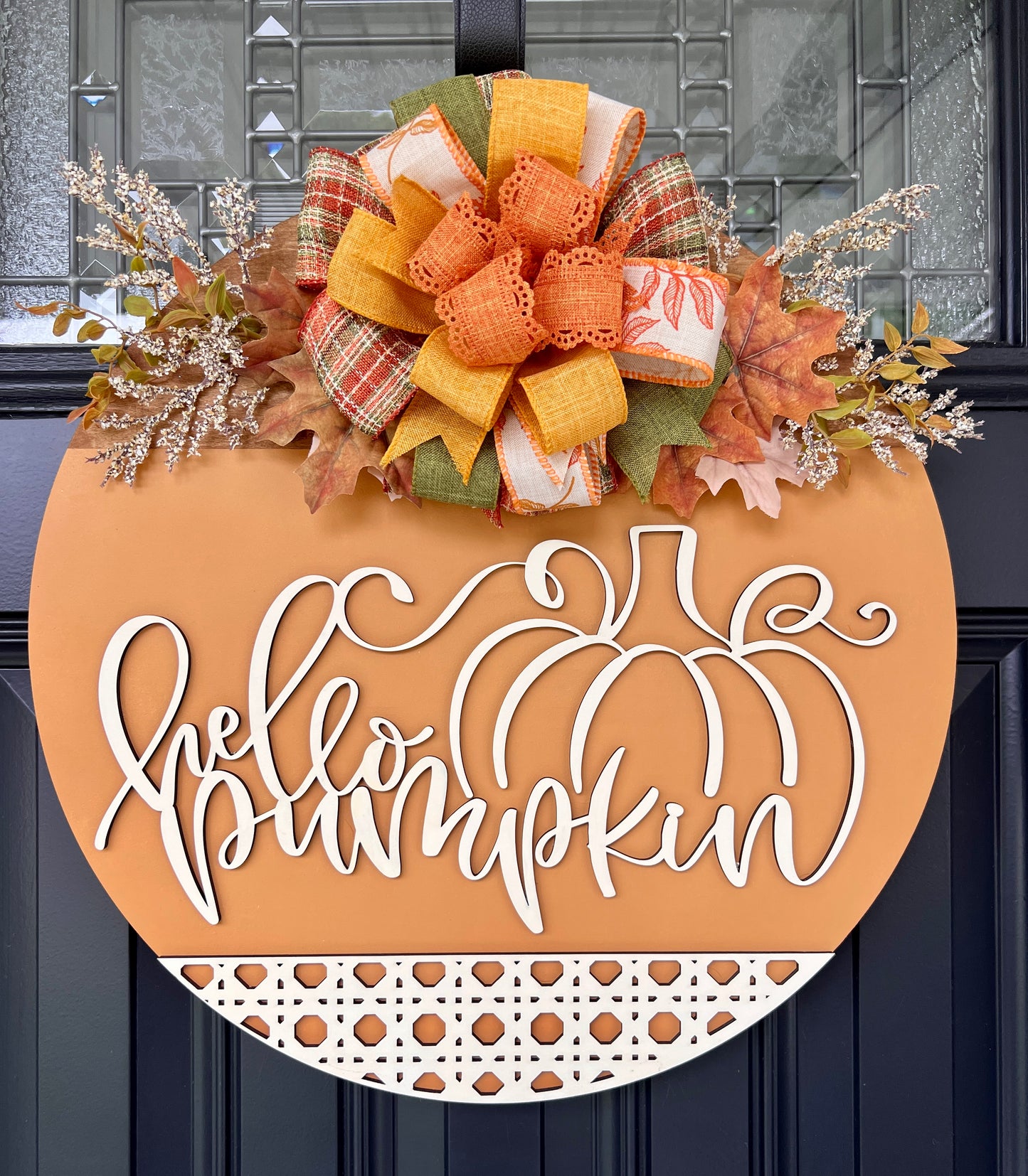 Hello Pumpkin fall door hanger on black front door with layered plaid and orange bow and fall leaves