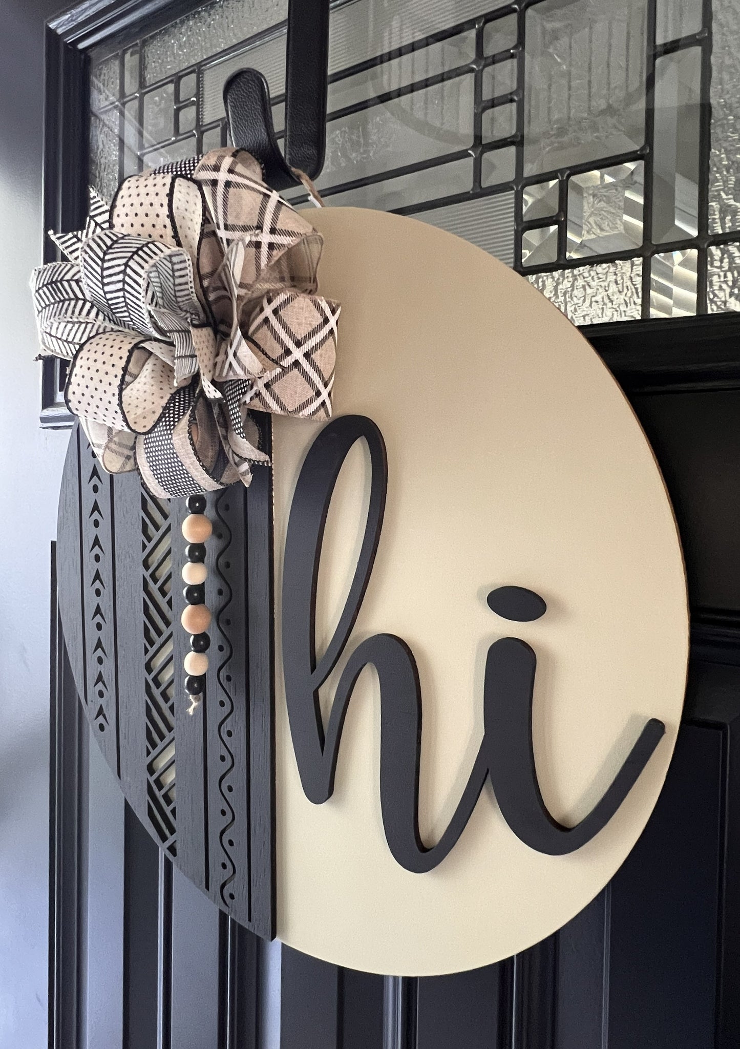 Decorative door hanger with plaid bow and 'Hi' text on a neutral cream background