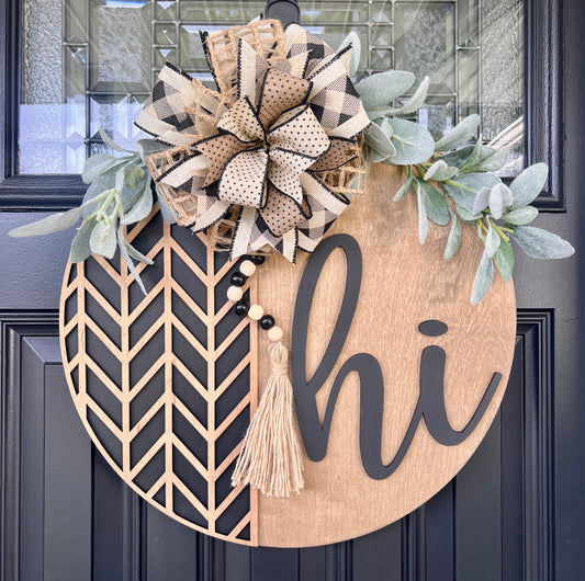 Decorative door hanger with floral elements and 'hi' text on a dark door.
