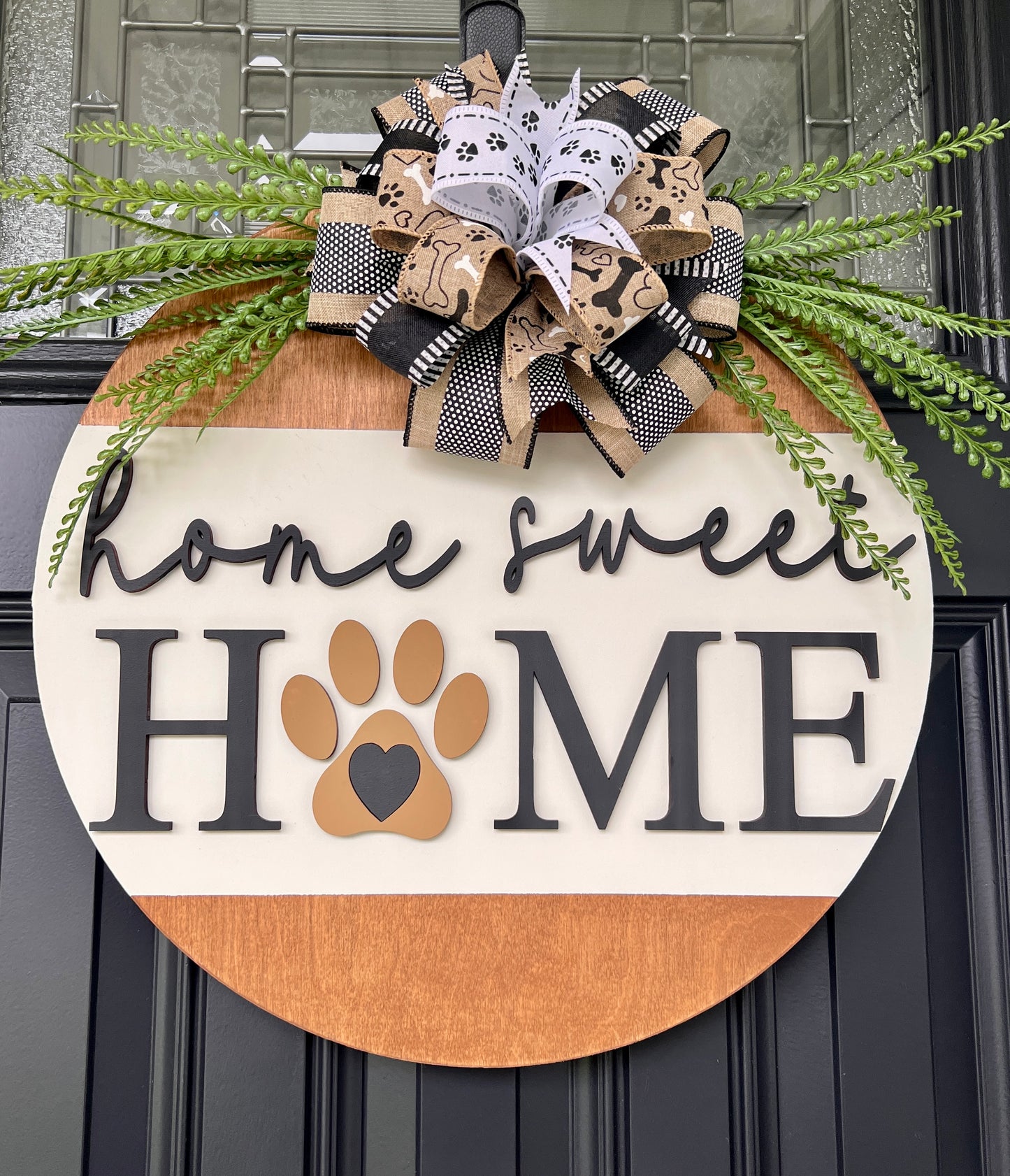 Home Sweet Home dog paw door hanger on black front door with layered dog bone and paw print bow and fern greenery