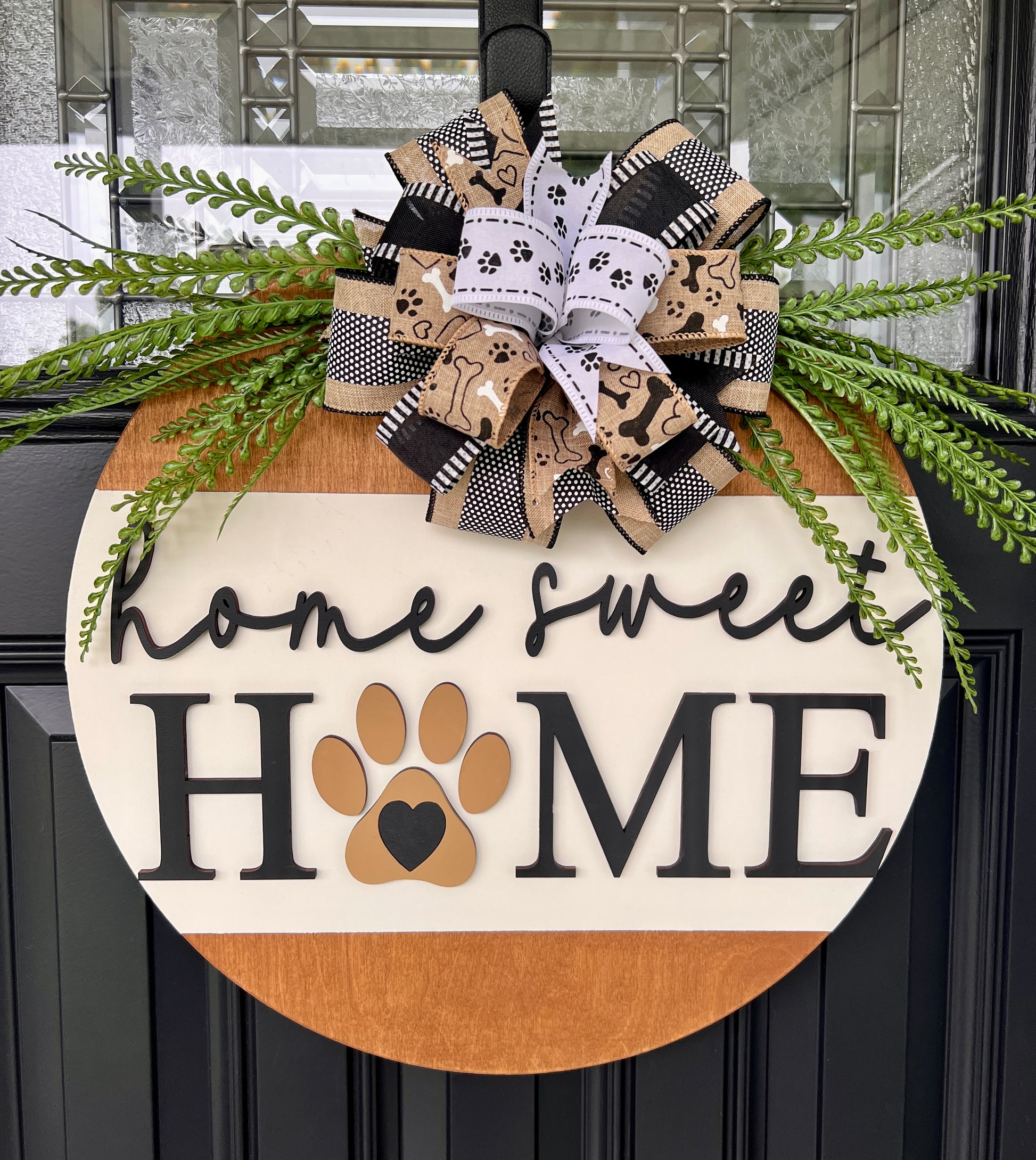 Home Sweet Home door hanger close up showing bow detail with dog bones paw prints and black white stripes