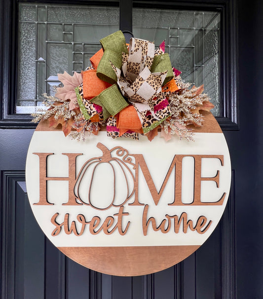 Fall door hanger with 'Home sweet home' and pumpkin design, featuring a Fall bow on Fall florals.