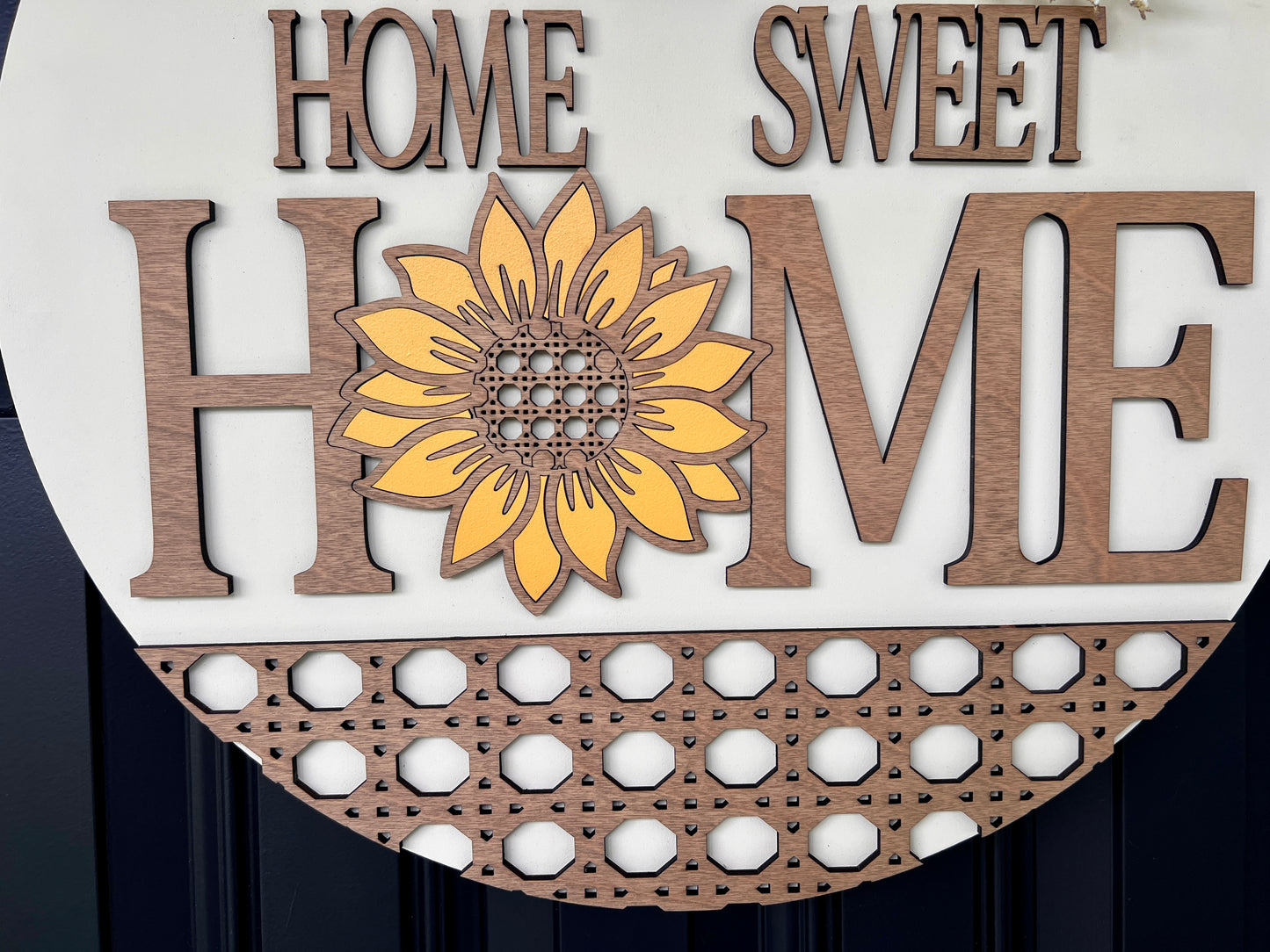 Home Sweet Home sunflower door hanger close up showing laser-cut rattan lattice border and sunflower centerpiece detail