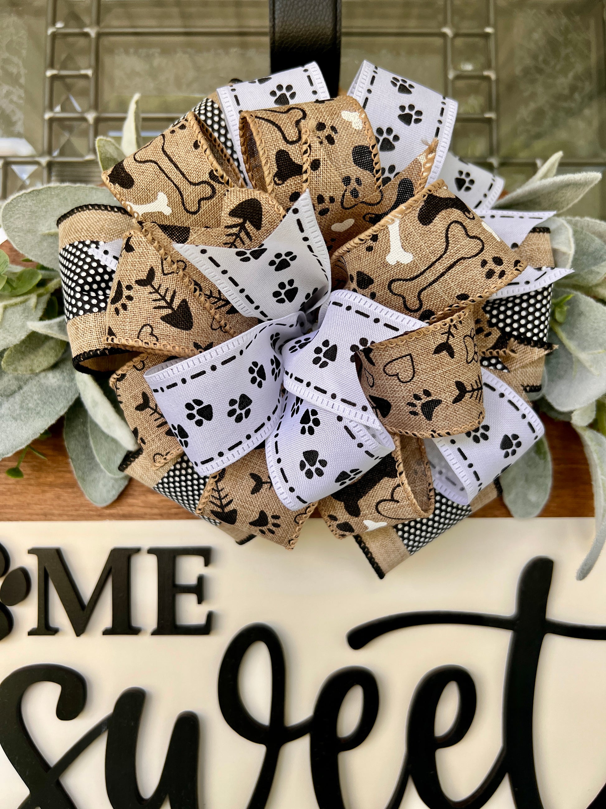 Home Sweet Home paw print door hanger close up of bow showing natural burlap dog bone paw print and white paw print ribbons