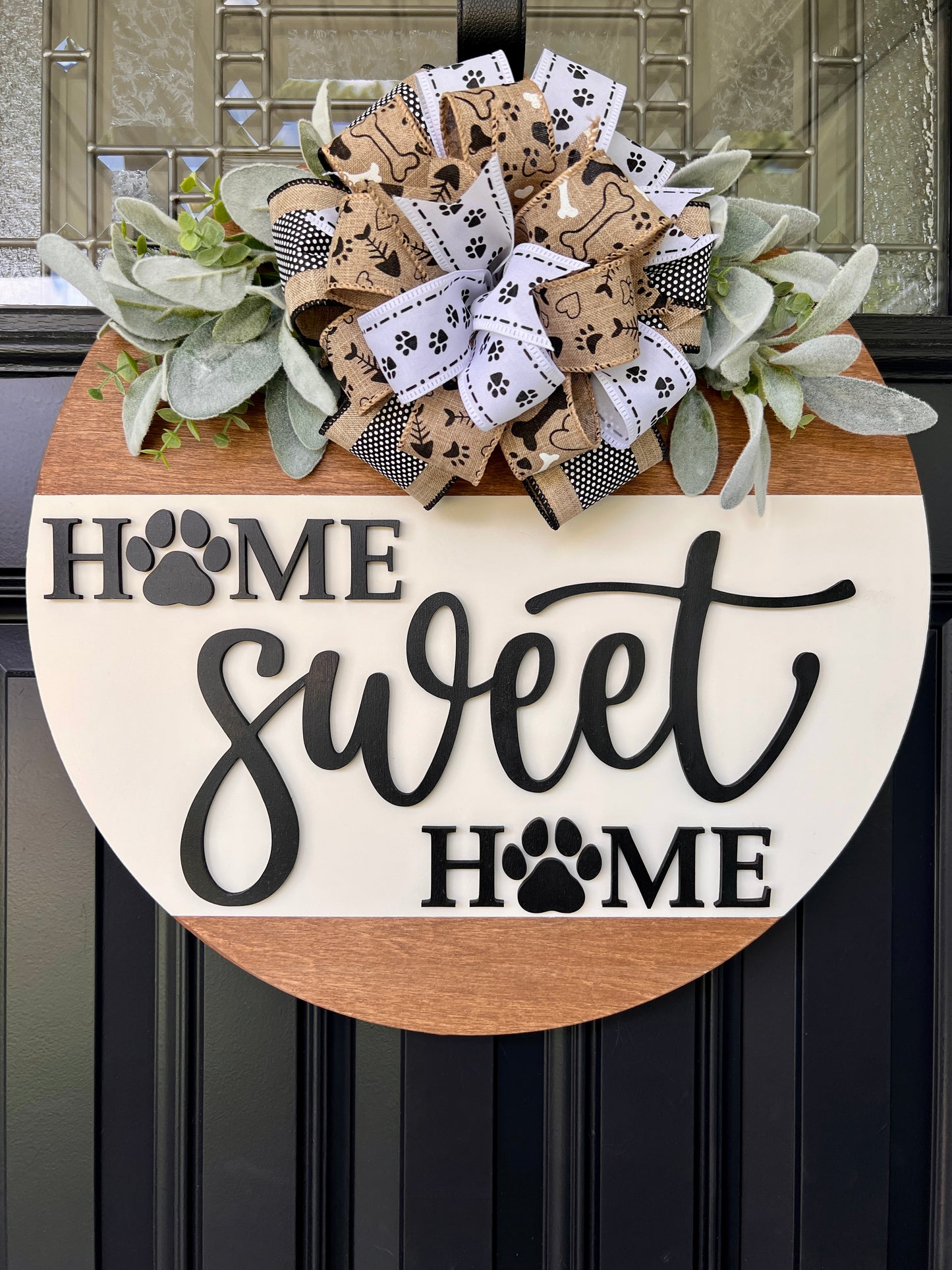 Home Sweet Home paw print door hanger full front view showing complete 18 inch two-tone round with warm stained upper panel and cream lower panel