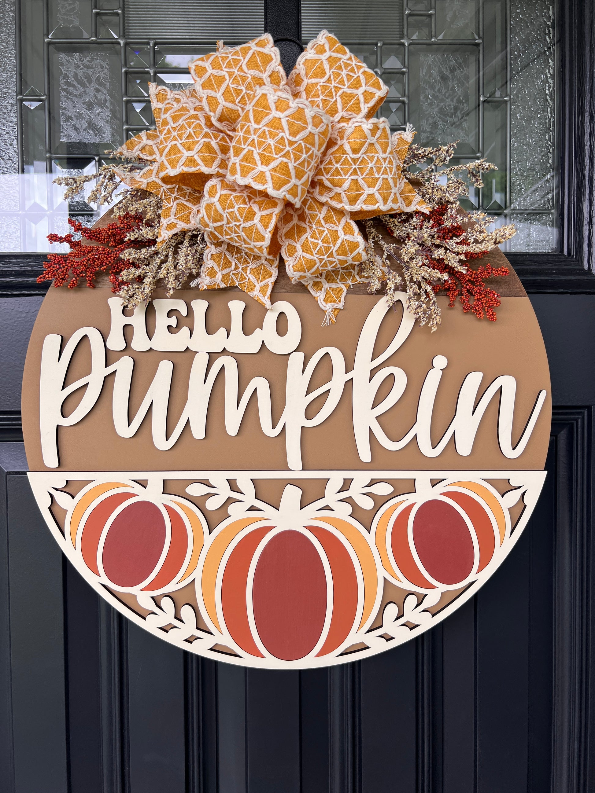 Hello Pumpkin Trio door hanger on black front door with mustard gold geometric burlap bow and red berry and cream dried floral sprays