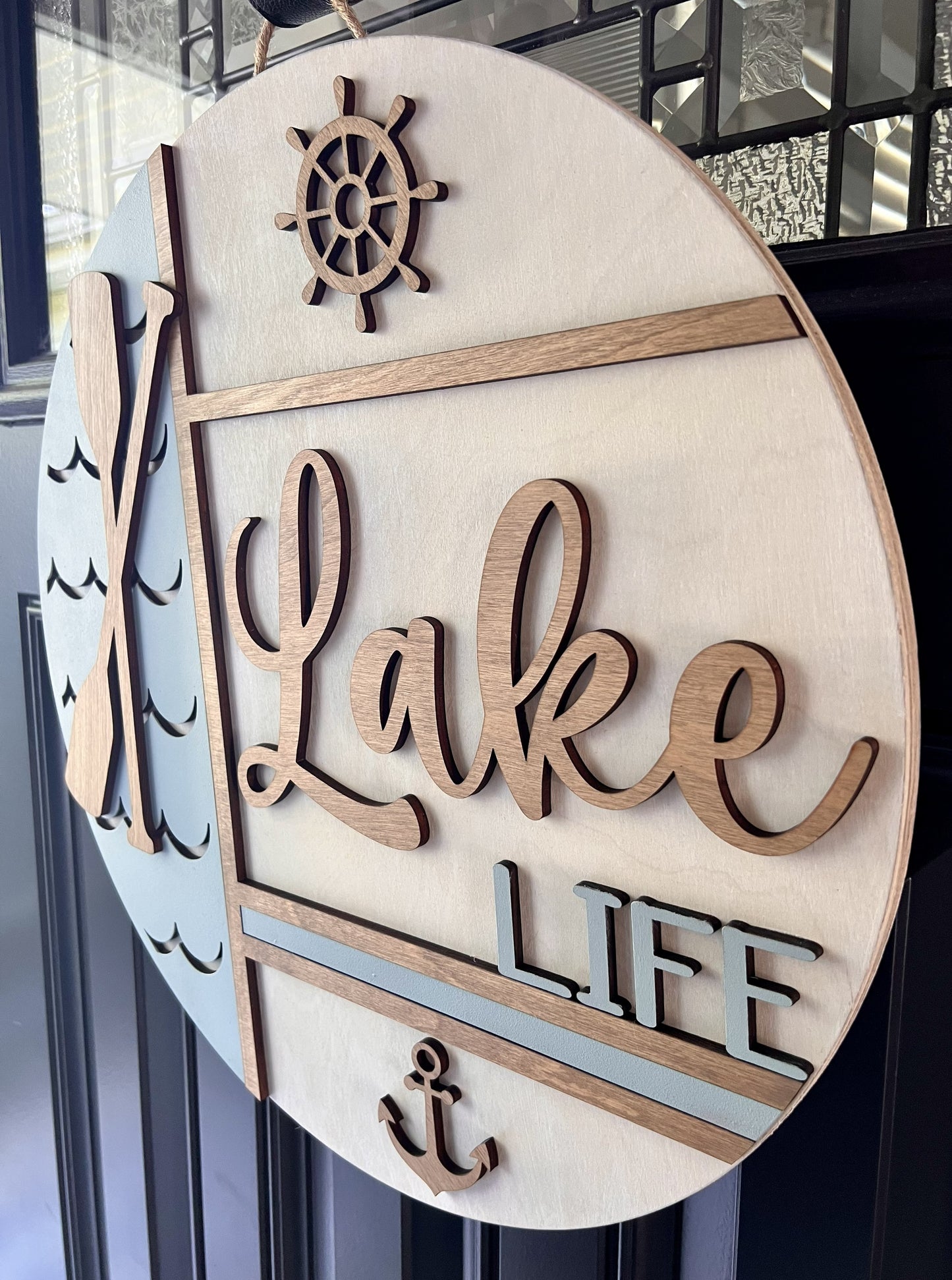 Wooden door hanger  sign with 'Lake Life' and a wheel design on a driftwood  white background