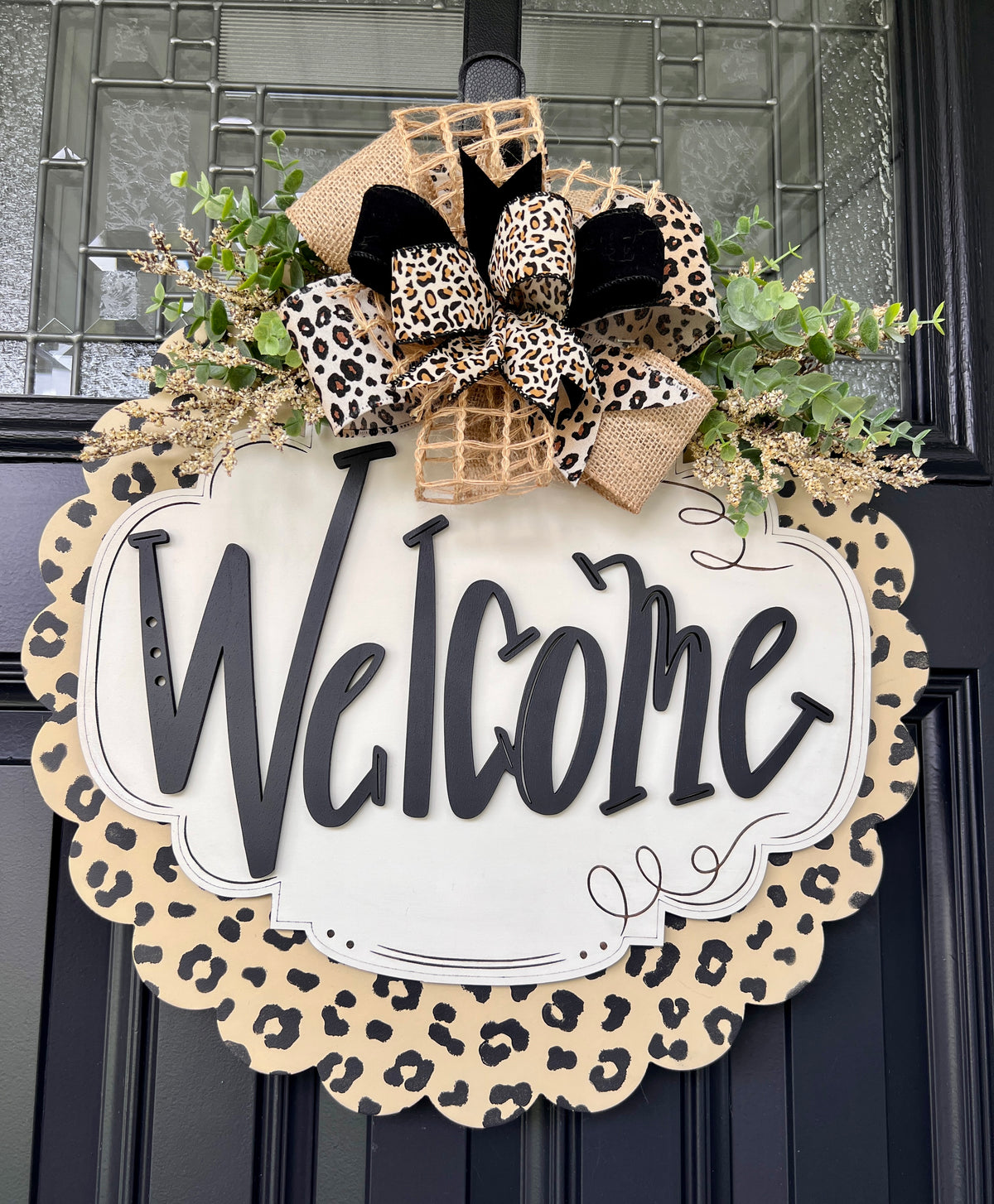 Close-up of leopard print scalloped border on Welcome door hanger