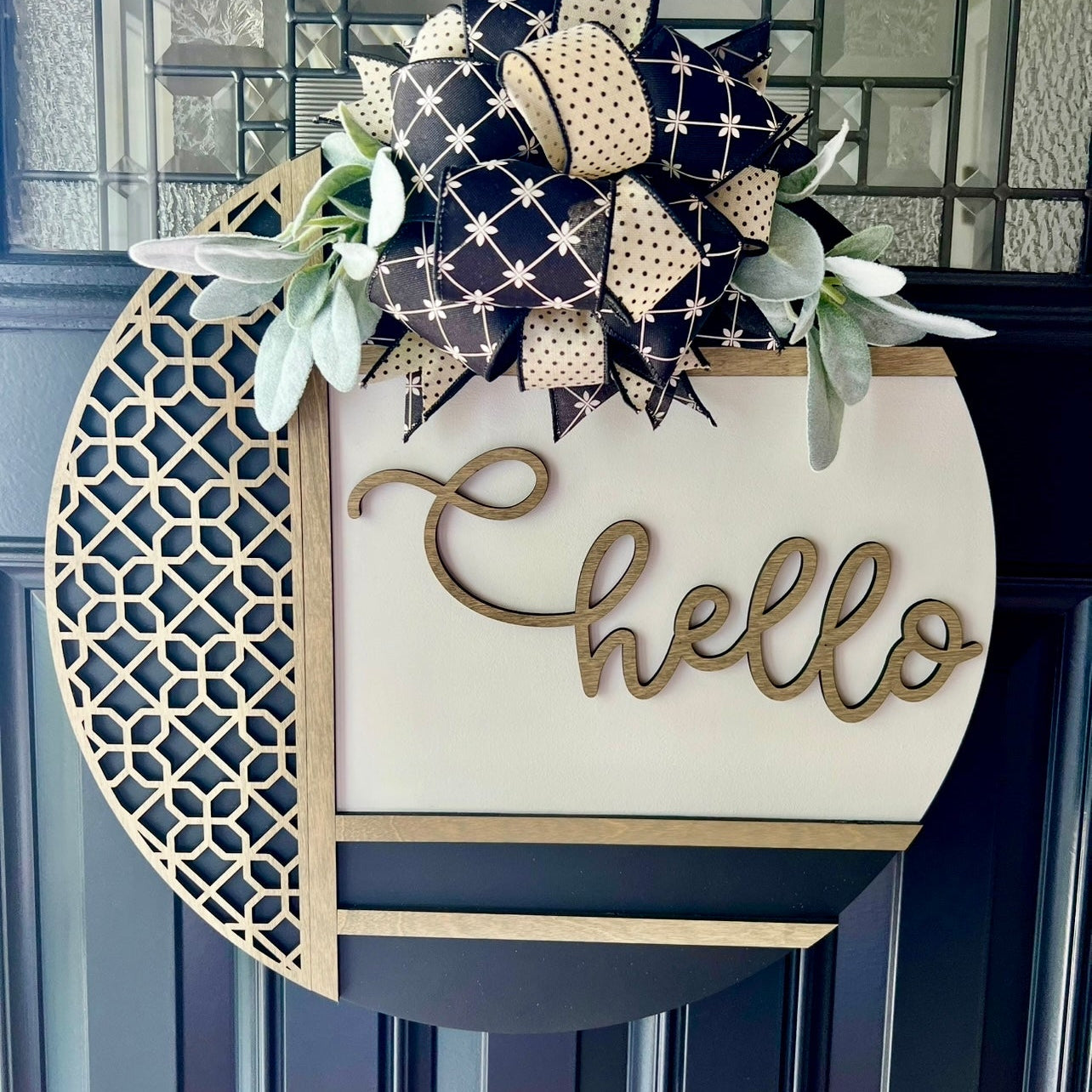 “Modern farmhouse hello door hanger with raised wood lettering, neutral bow, and greenery on front door”