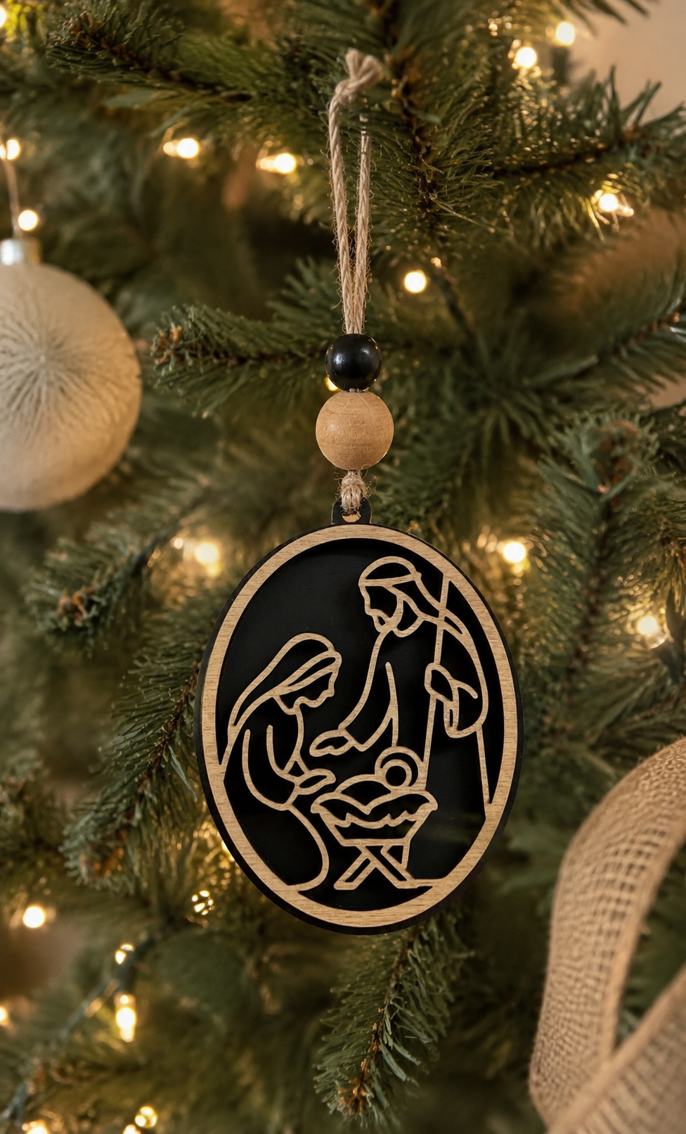 Wooden nativity ornament black stain with twine and beads on white background