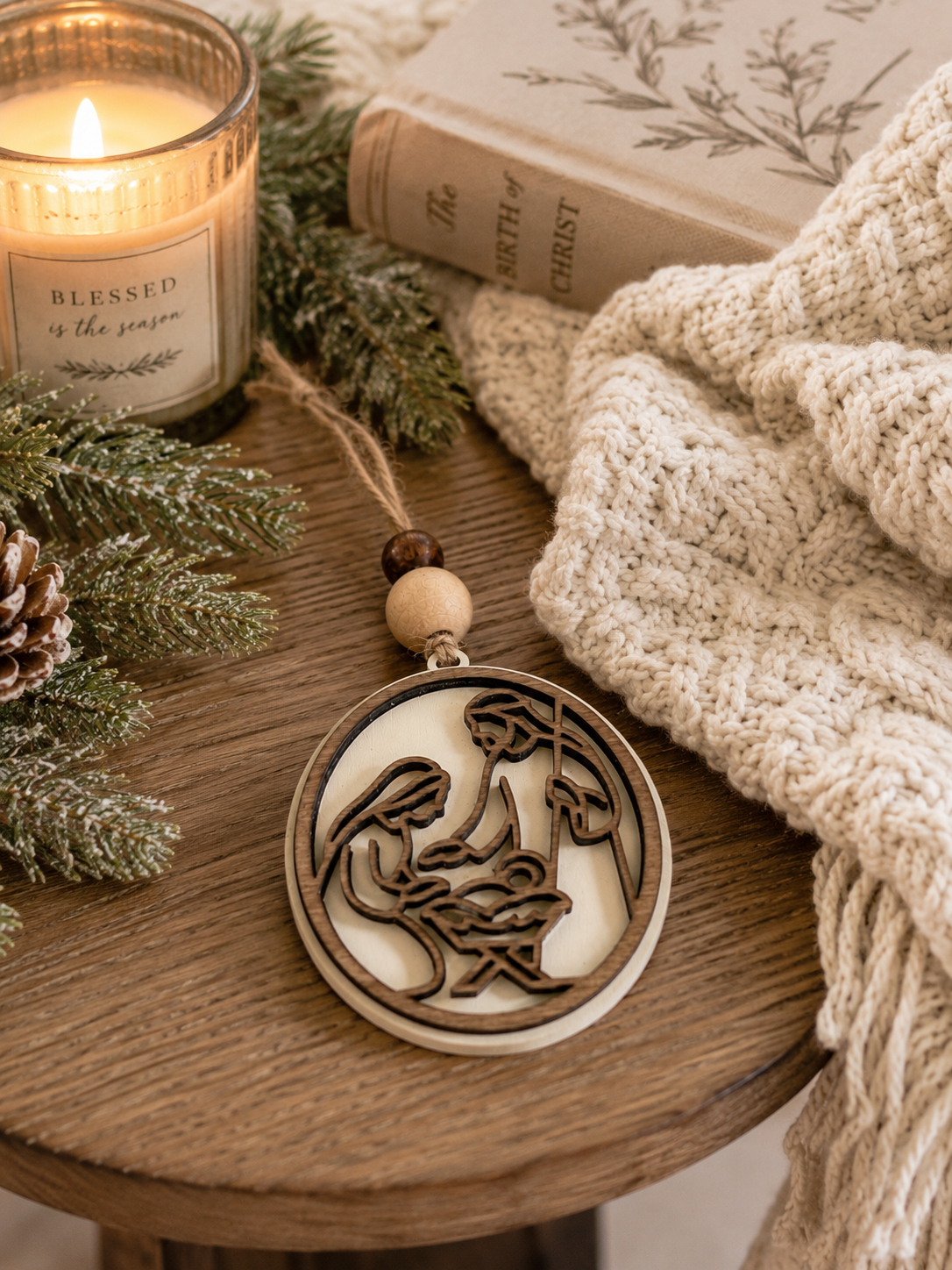 Cream nativity ornament on white background showing Mary Joseph and Baby Jesus