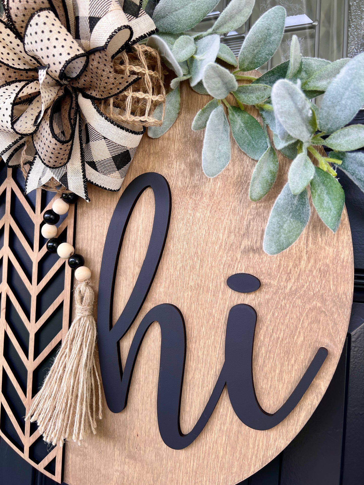 Birchwood doorhanger with 'hi', decorative bow, beaded tassel, and greenery.  