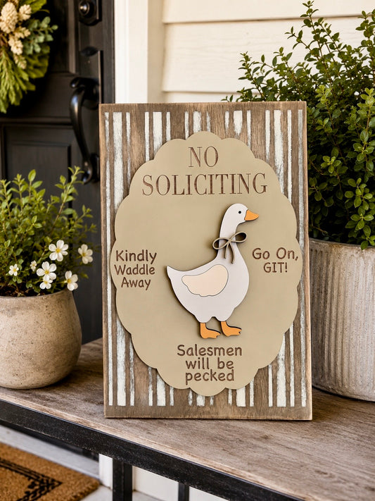 No Soliciting goose sign lifestyle shot on porch table with potted plants showing full 12x18 rectangular sign