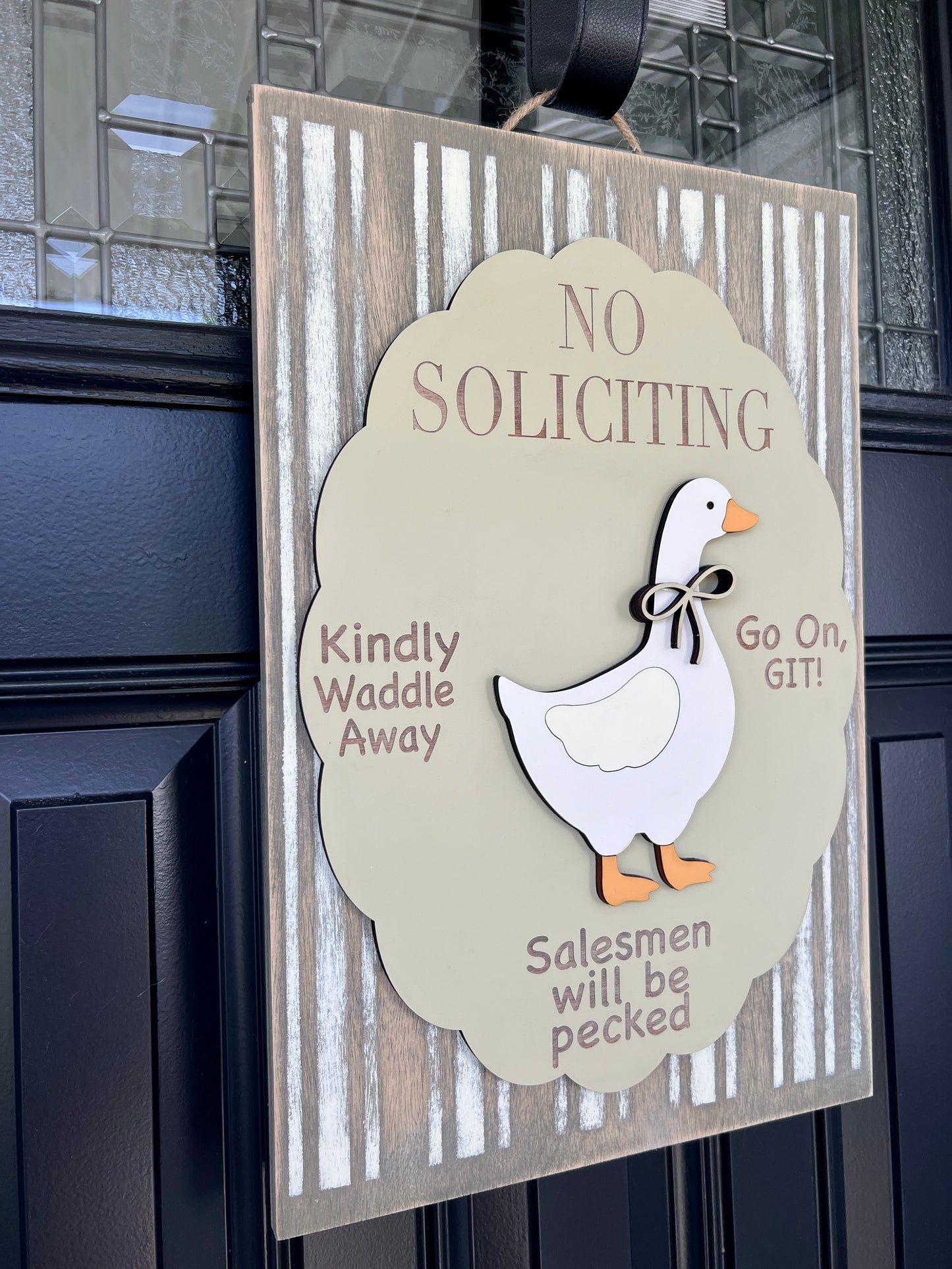 No Soliciting goose door sign on black front door showing Kindly Waddle Away Go On GIT and Salesmen will be pecked text