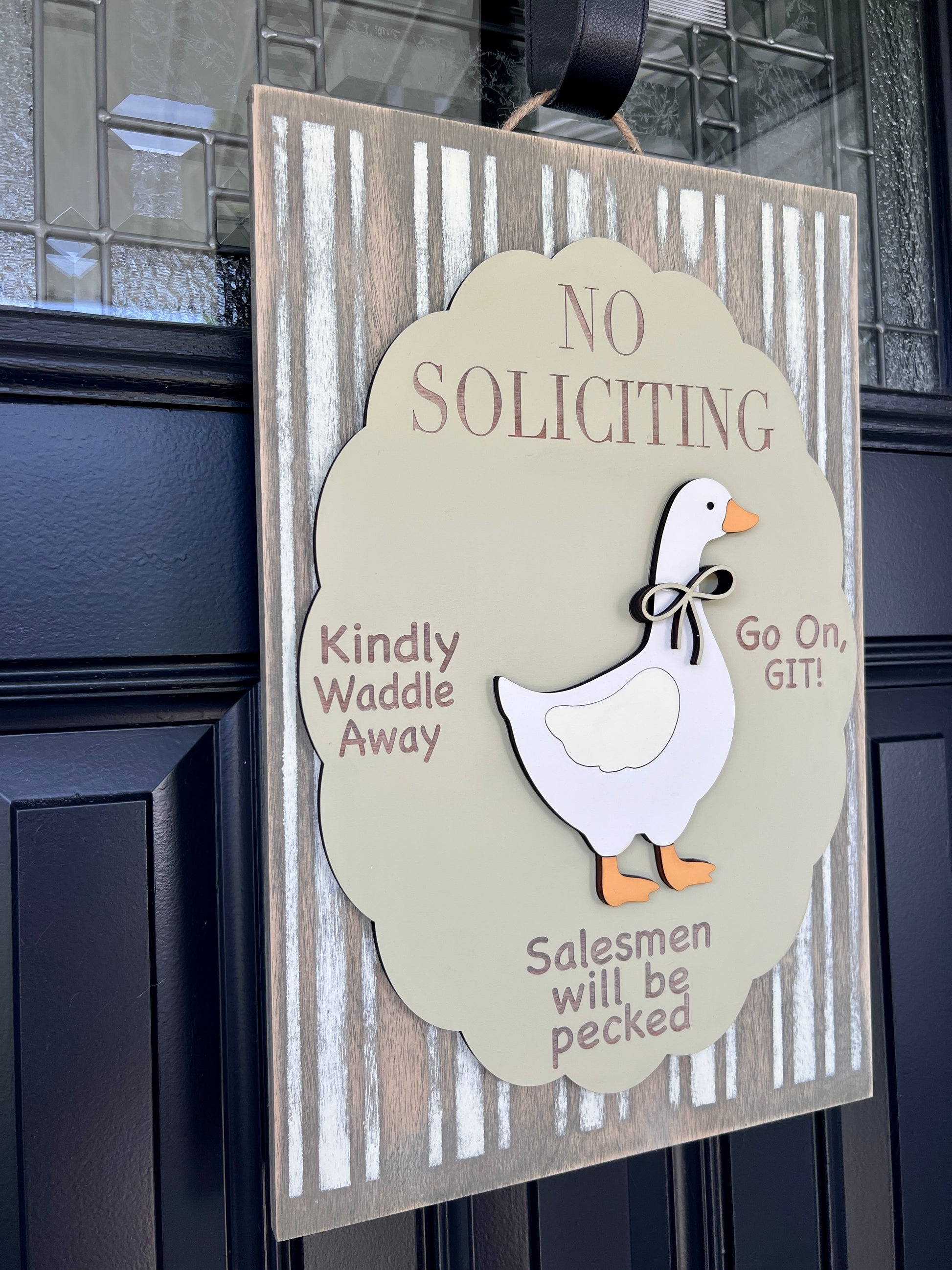 No Soliciting goose door sign on black front door showing Kindly Waddle Away Go On GIT and Salesmen will be pecked text