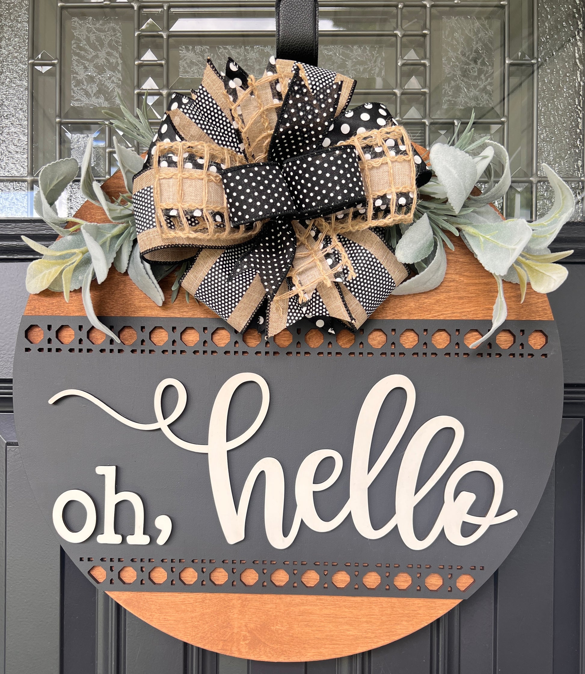 Detail of handcrafted designer bow made with premium black, cream, and burlap ribbons.
Close-up of laser-cut decorative border and dimensional wood lettering.