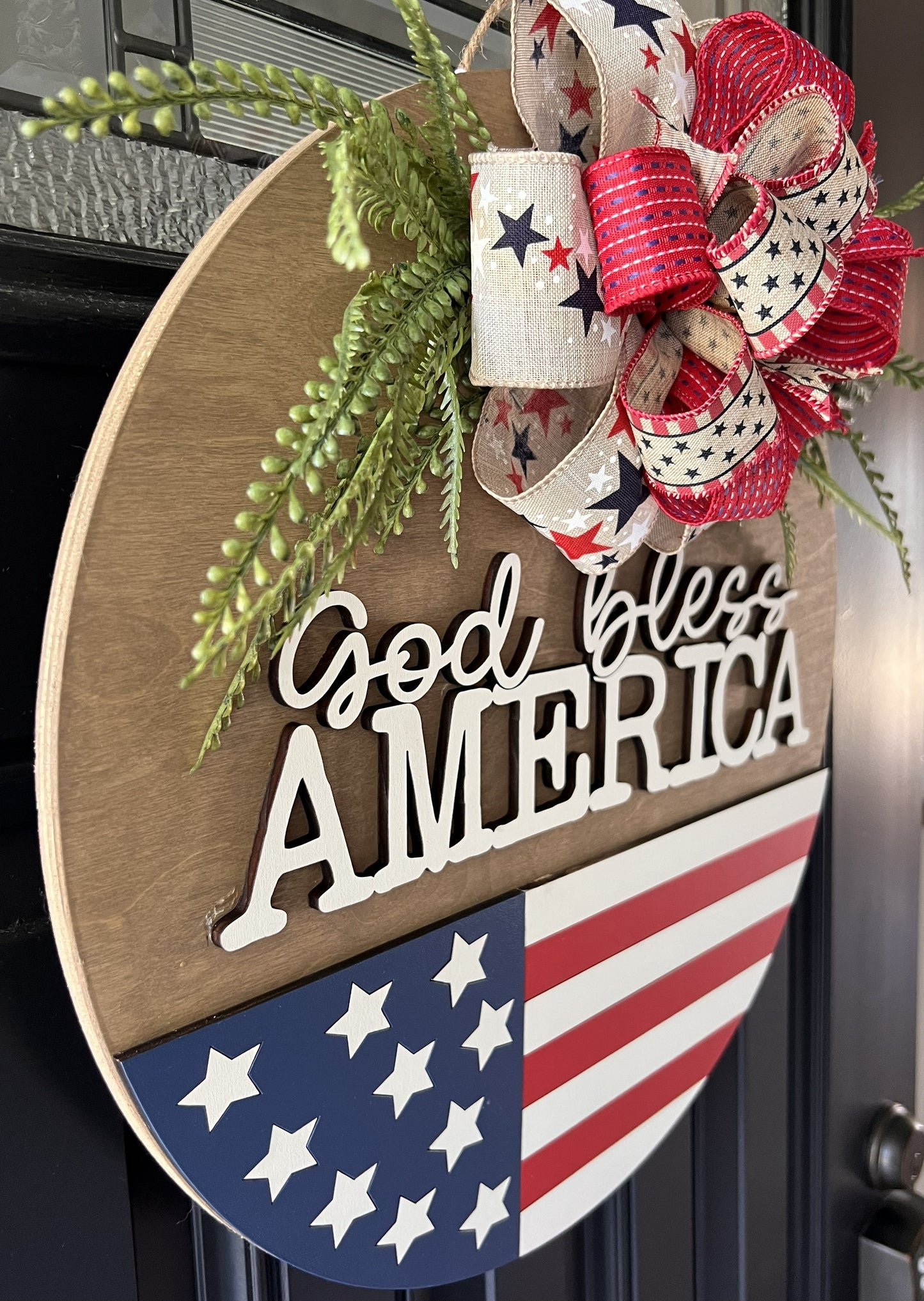 Decorative sign with 'God bless America' text and American flag design.