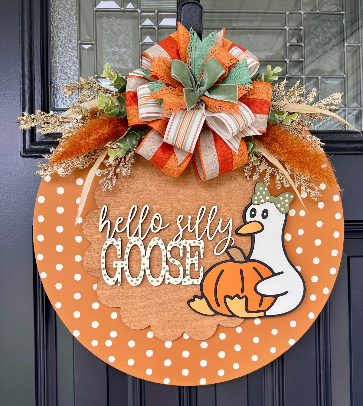 Fall door hanger with sage green and orange bow on black door - straight on view