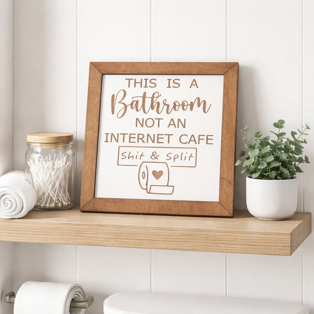 This Is a Bathroom Not an Internet Cafe funny wood sign styled on a bathroom shelf with cotton swabs jar, rolled towels, and green plant