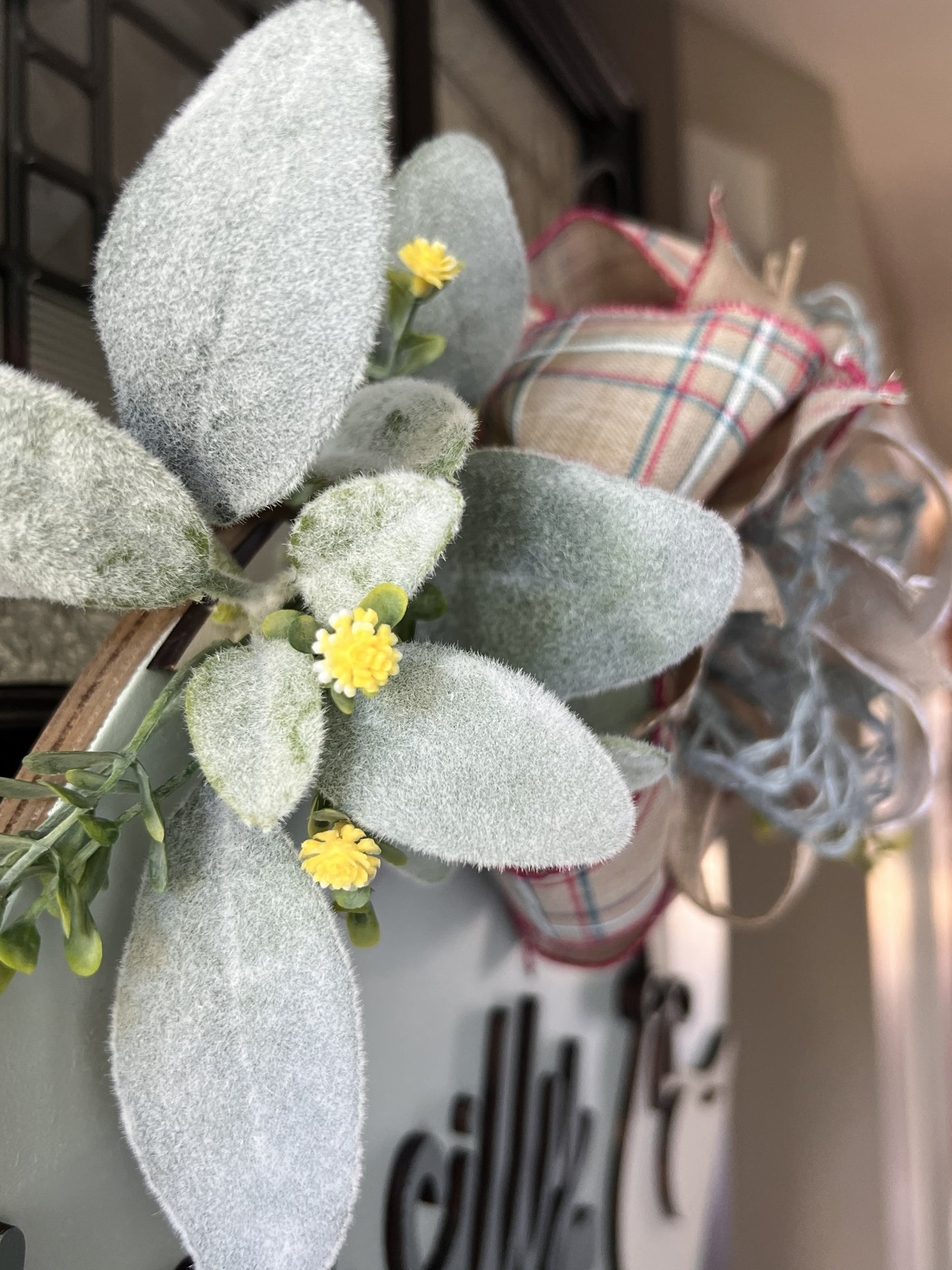 Decorative wreath with lamb's ear greenery, small yellow flowers, door hanger, silly goose.  